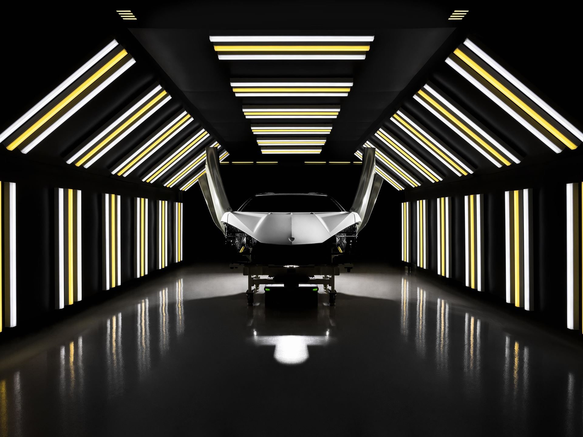 Lamborghini'S Museum Turns Its Own Factory Into Fine Art With Lucrezia Roda'S 'The Industrial Perspective' 3 A white lamborghini chassis with scissor doors open on a futuristic assembly line illuminated by vertical amber and white lights
