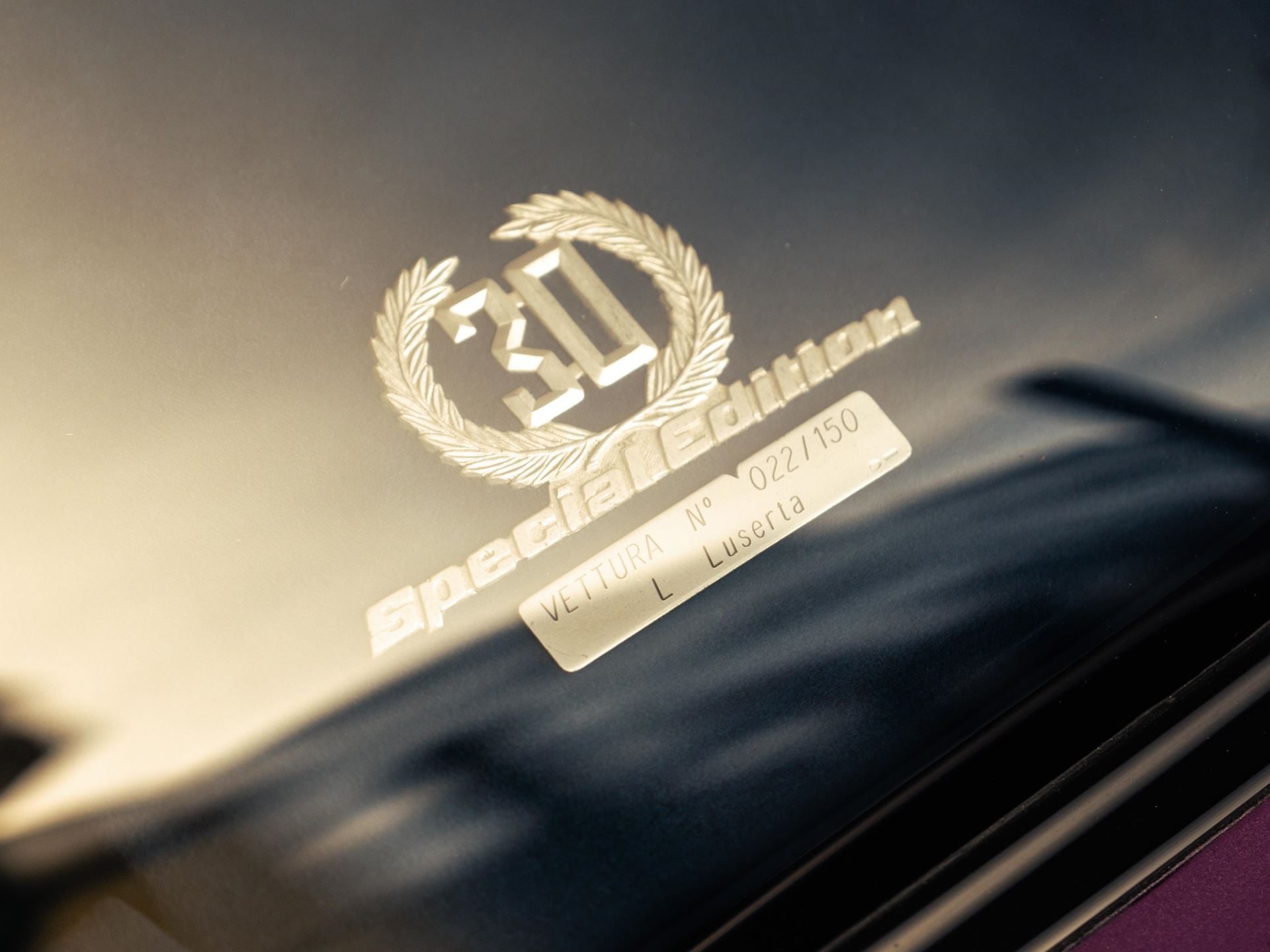 Close-up of the special edition 30 badge and vettura n° 022/150 plaque on the window of the purple lamborghini diablo se30