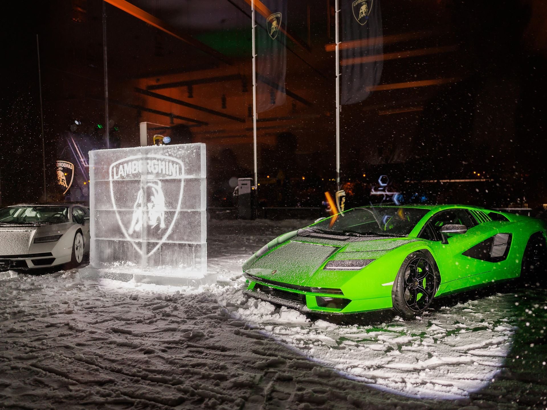 Lamborghini Prague Moves To Ořech With Fenomeno, Temerario, And A Full Hybrid Lineup On Display 5 Two lamborghini countach lpi 800-4 models in green and white displayed outdoors in snow next to an illuminated ice sculpture of the lamborghini logo