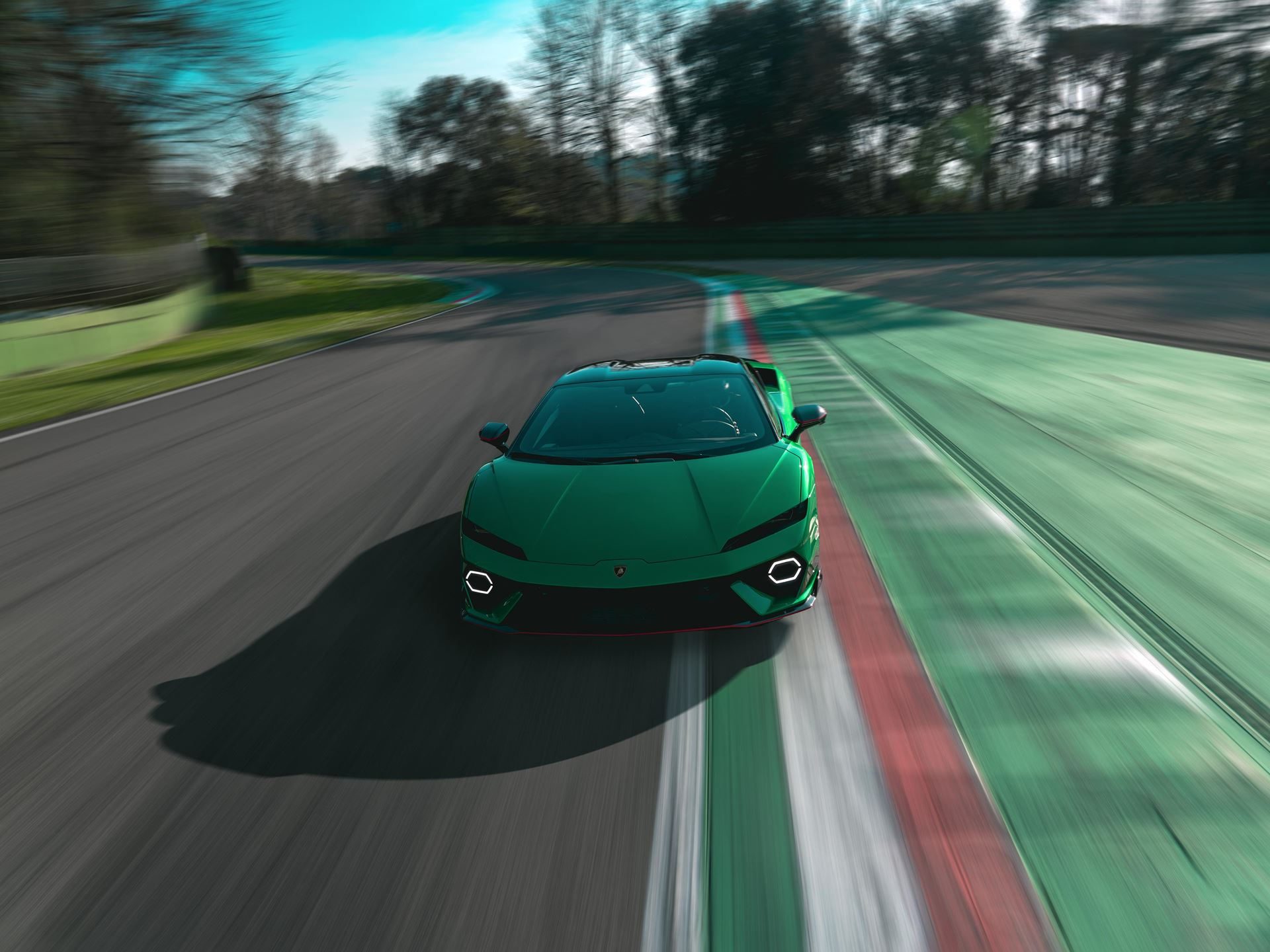 A vibrant green lamborghini revuelto at speed on a race track with motion blur highlighting its aerodynamic profile