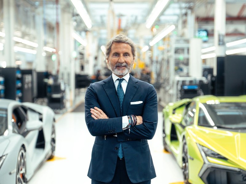 Stephan Winkelmann, CEO of Lamborghini, standing between two Revuelto supercars on the production line