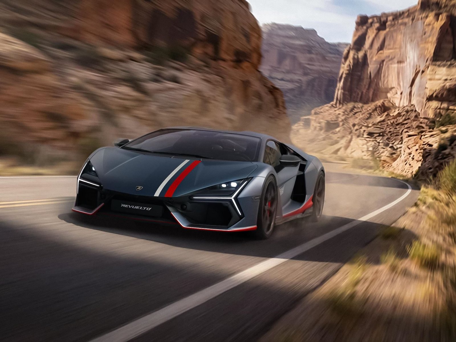 Dark grey Lamborghini Revuelto NA63 with red, white, and blue racing stripes speeding along a mountain road