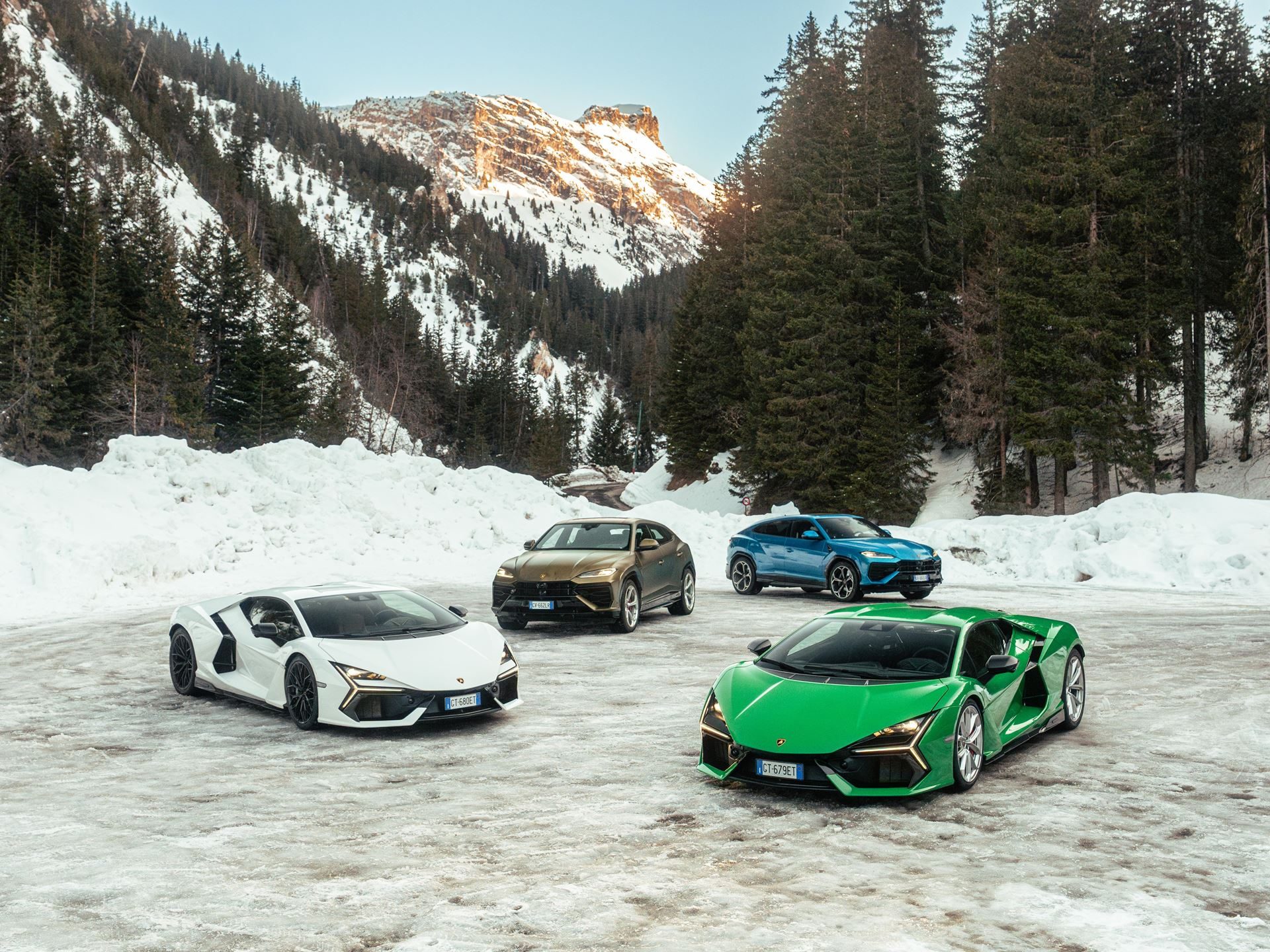 Lamborghini Took Its Hybrid Lineup To The French Alps, And The Convoy Included A Surprise Guest 7 Four lamborghini models including a white revuelto, green revuelto, gold huracan sterrato, and blue urus parked on snow with mountains behind