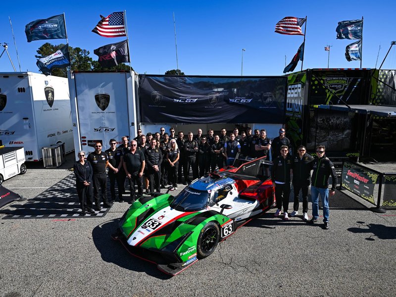 The Lamborghini SC63 LMDh race car displayed in the Road Atlanta paddock with the full Squadra Corse racing team and support staff