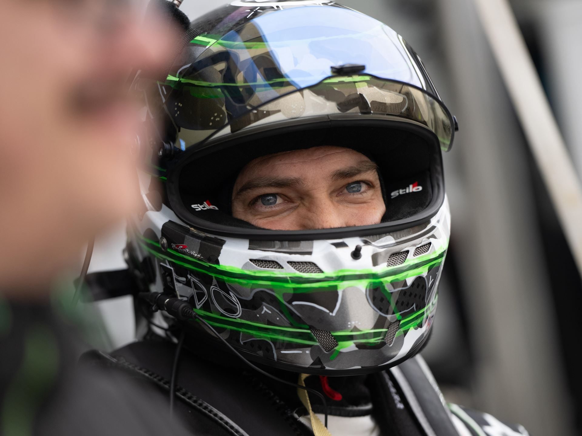 Lamborghini Sc63 Returns To Its Breakthrough Circuit At Indianapolis, Carrying Watkins Glen Momentum 7 Close-up portrait of a lamborghini factory driver in green and white camouflage helmet