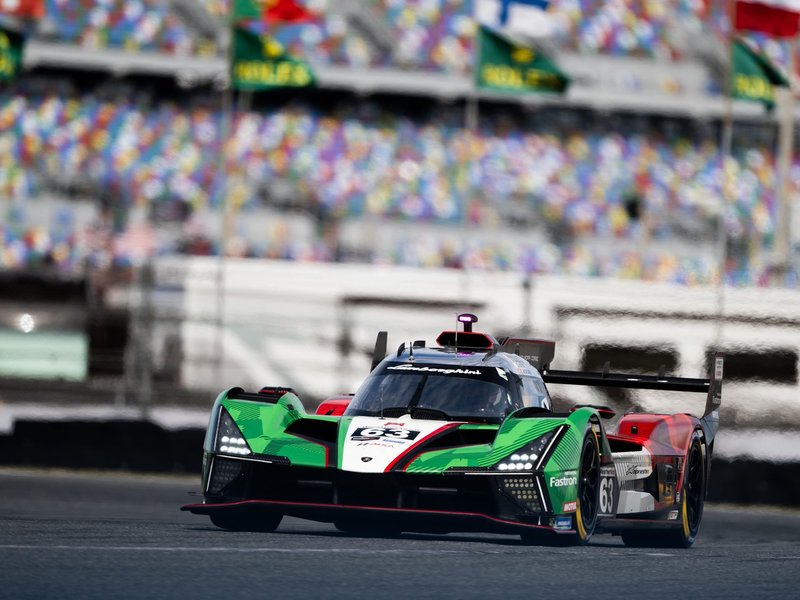 The Lamborghini SC63 in green, white and red livery at speed on a racetrack