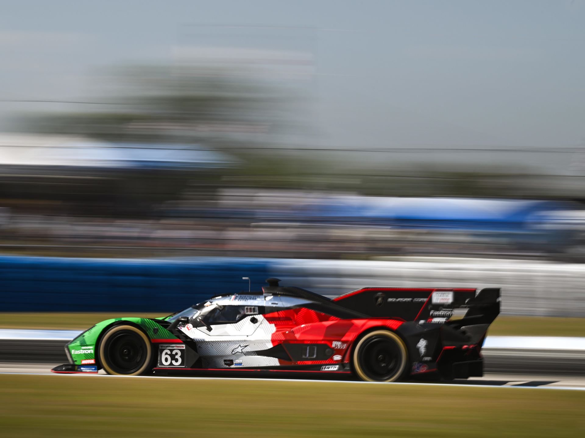 Side profile of the lamborghini sc63 number 63 on track showing its low-slung aerodynamic shape and tricolore livery