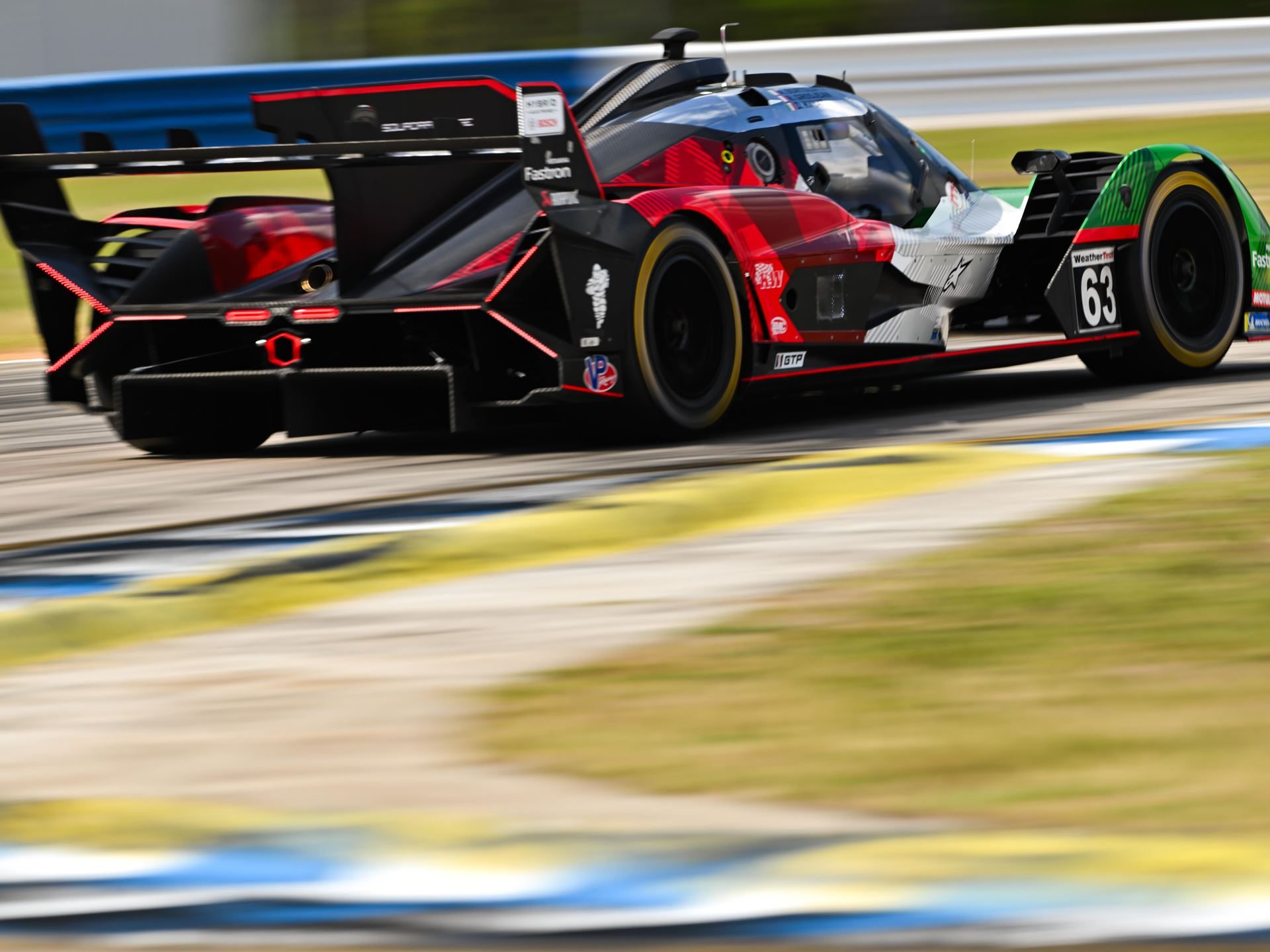 Rear three-quarter view of the lamborghini sc63 number 63 on track showing the large rear diffuser and wing