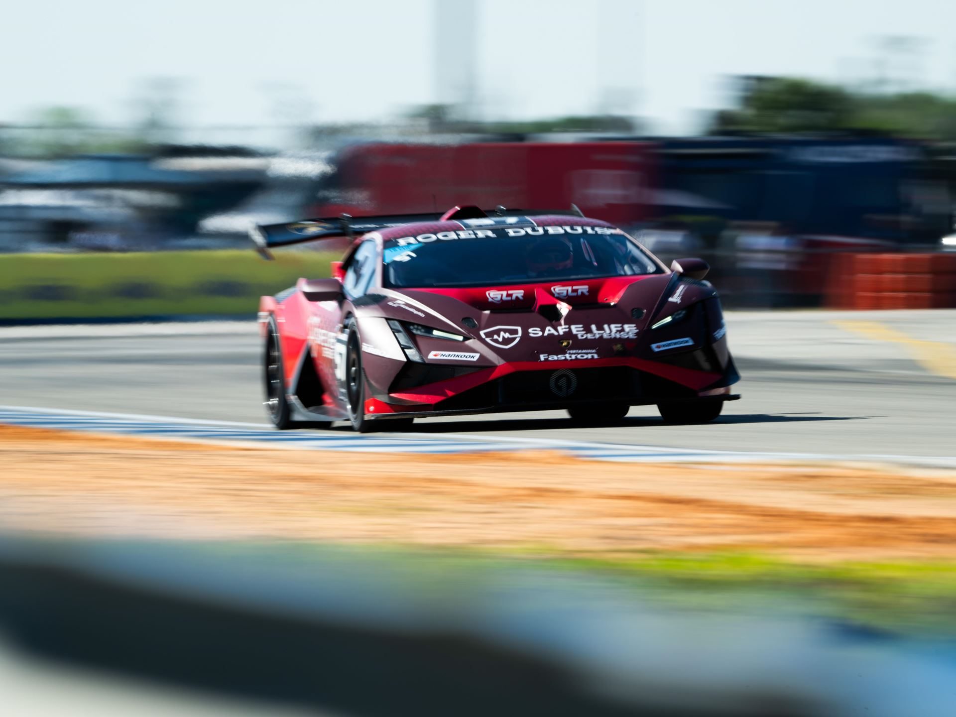 41 Huracáns Head To Laguna Seca As Wayne Taylor Racing Carries Five-Win Sebring Momentum 9 A red and black lamborghini huracán super trofeo evo2 race car speeding through a turn with motion blur on a race track