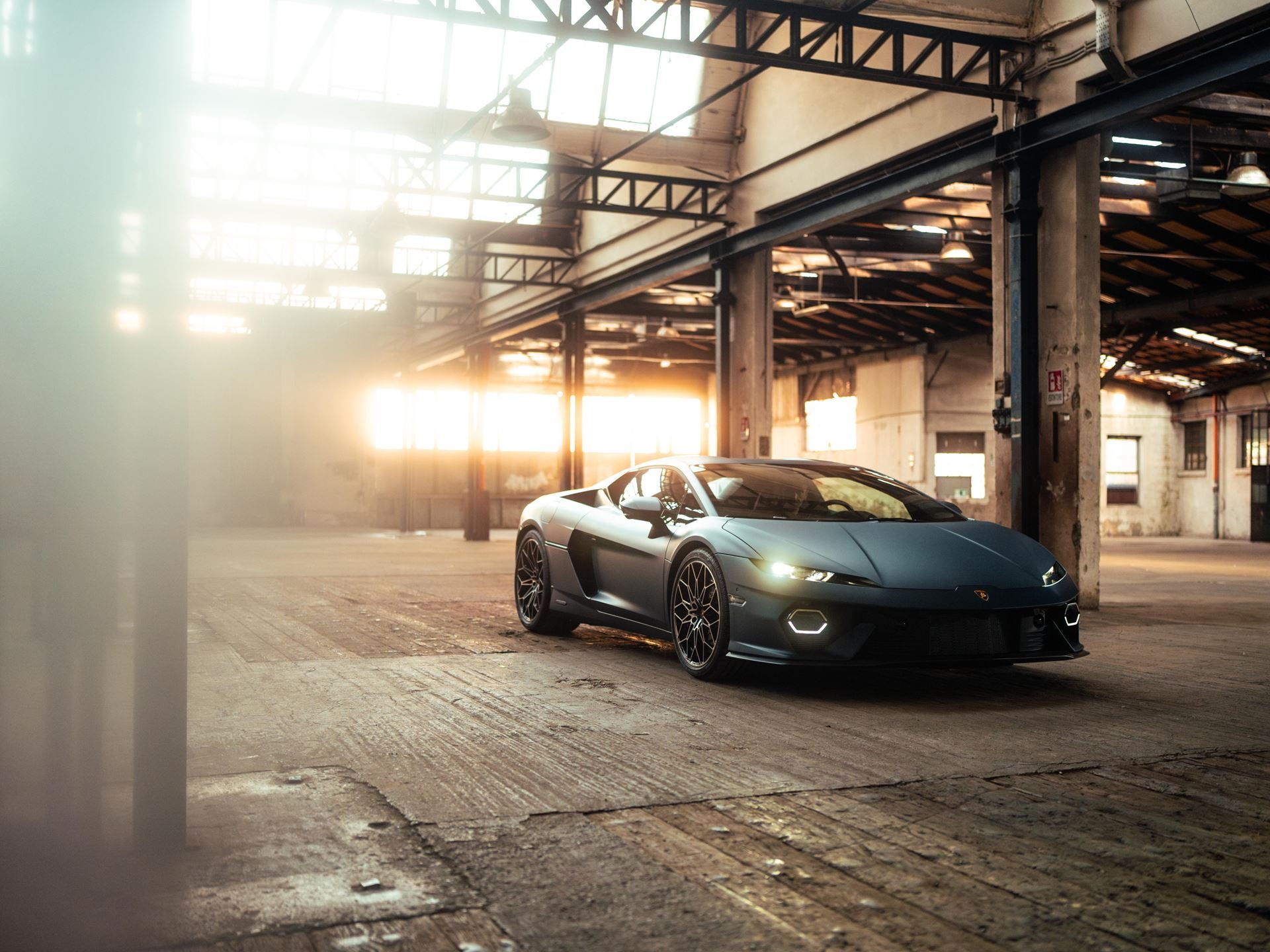 Lamborghini Temerario: Every Surface Works For Speed, And A Swimmer Explains Why 7 Wide-angle view of the matte blue lamborghini temerario in a sunlit industrial warehouse