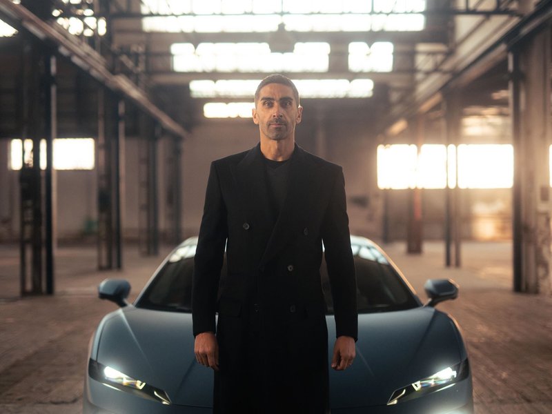Matte blue Lamborghini Temerario in an industrial warehouse with Filippo Magnini standing nearby