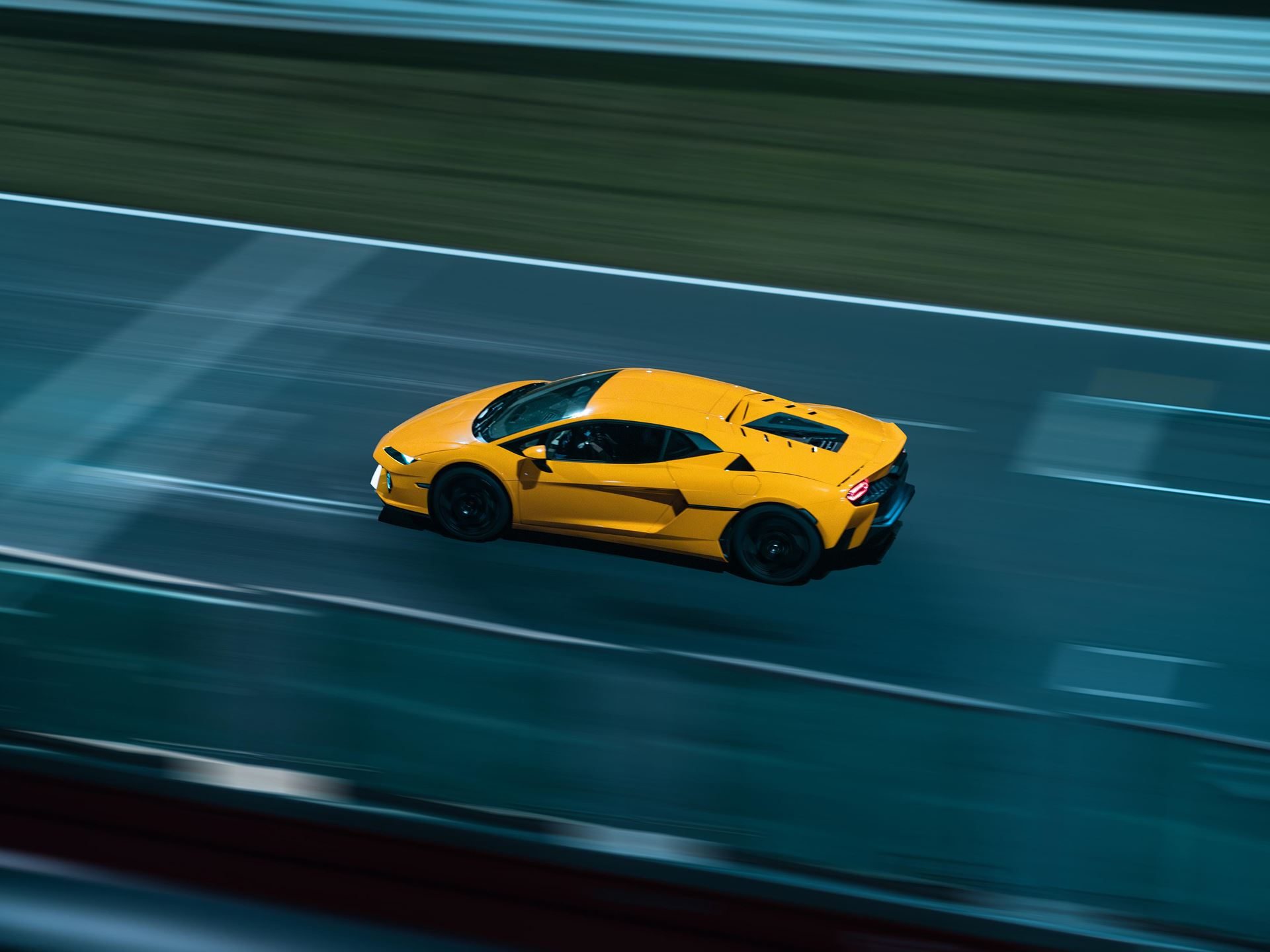 Aerial view of yellow lamborghini temerario at speed on a racetrack with motion blur