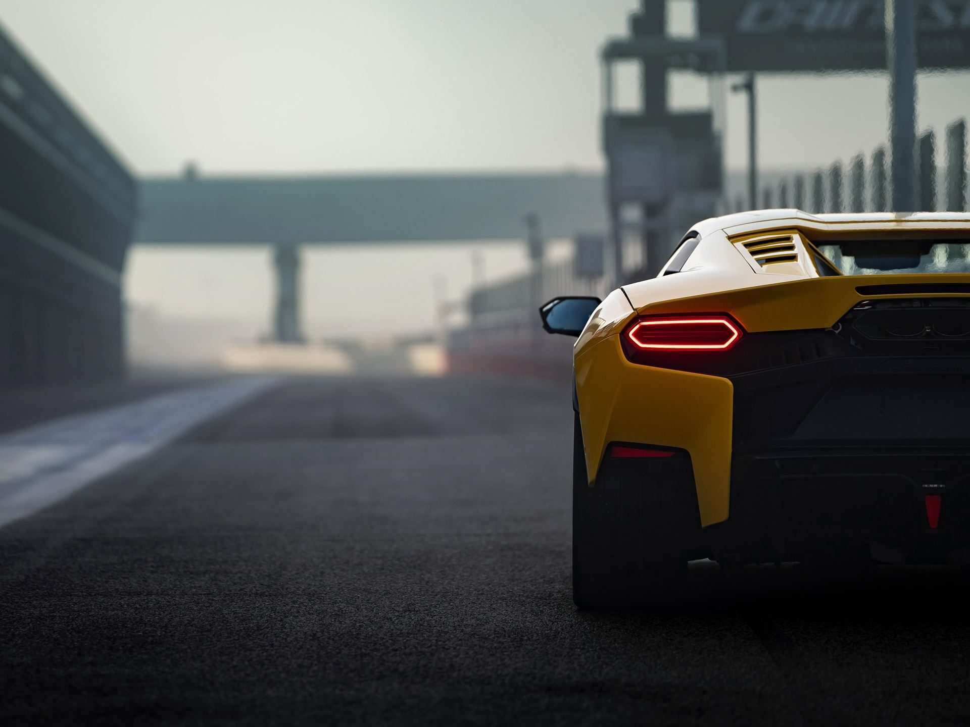 Close-up rear view of yellow lamborghini temerario showing hexagonal taillights and rear diffuser on track