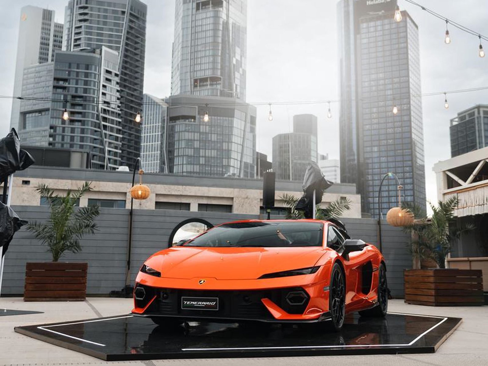 Lamborghini Temerario displayed on a rooftop event space with a city skyline in the background