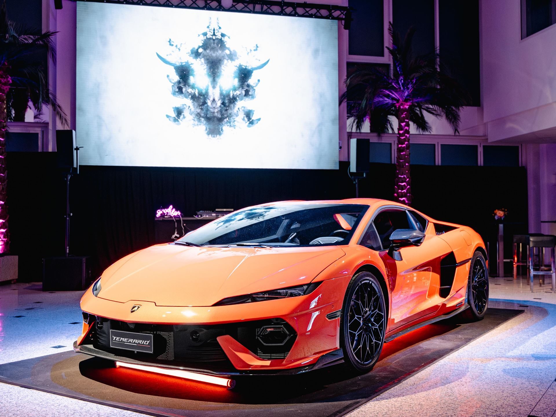 Lamborghini'S 4,000-Kilometer Temerario Tour Reveals How Seriously Sant'Agata Takes Germany 7 Lamborghini temerario displayed on a platform with ambient lighting against an abstract art backdrop