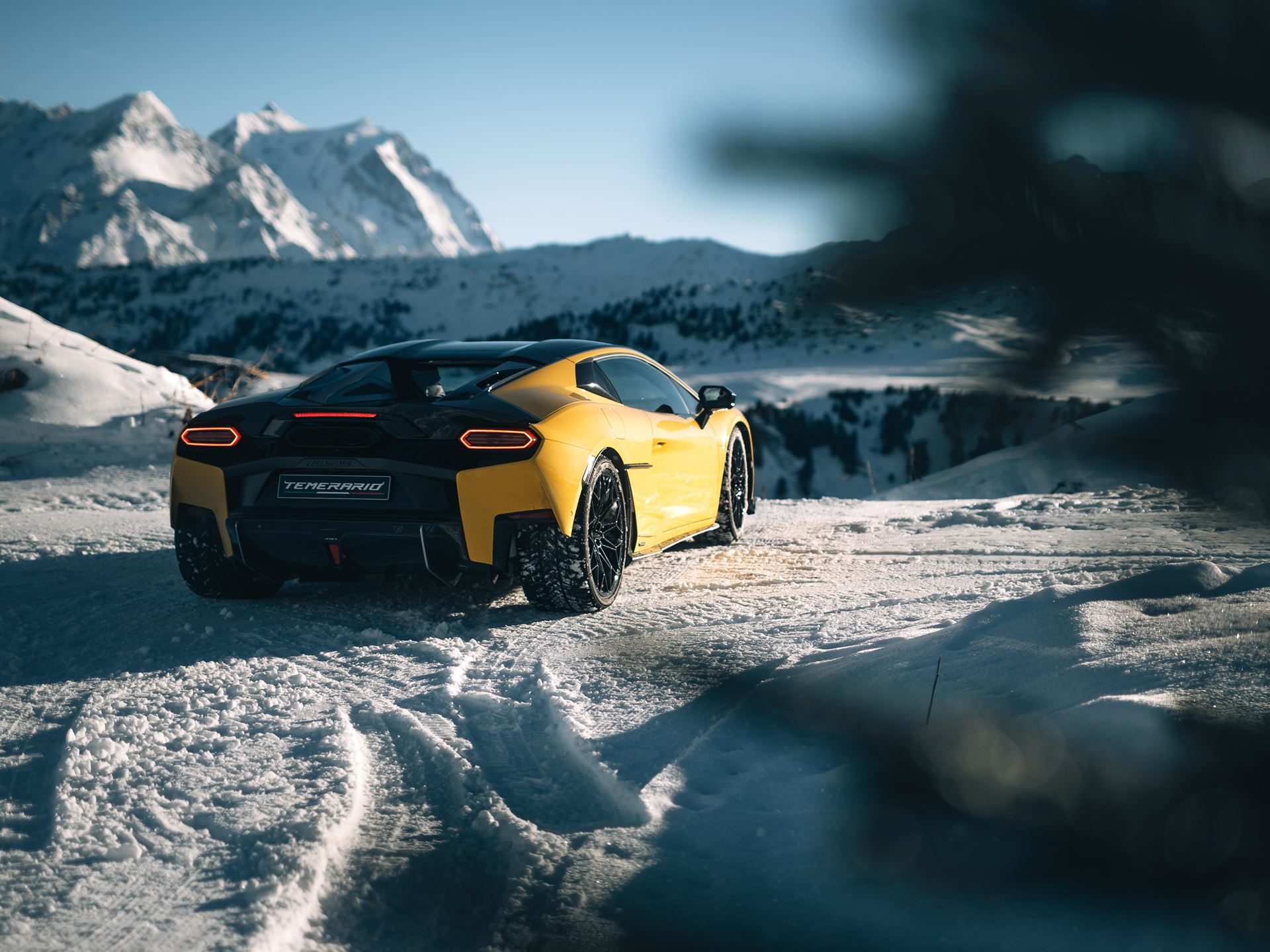 Lamborghini'S Temerario Drifts On Alpine Ice, Proving Its Hybrid System Works Where Grip Doesn'T 11 Yellow lamborghini temerario parked on snowy road facing snow-covered mountain panorama