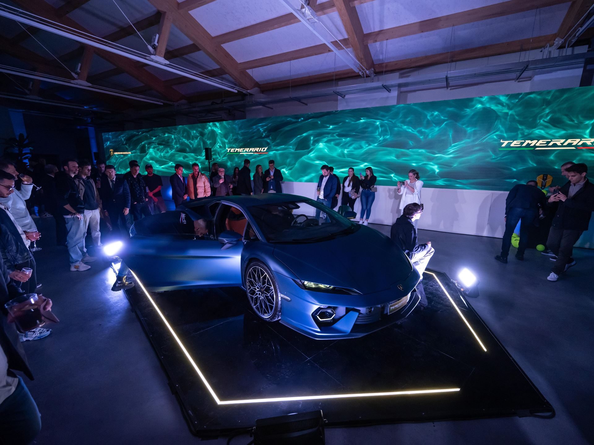 Lamborghini Temerario: A 10,000 Rpm V8 And Three Electric Motors Replace The Huracán 3 Blue lamborghini temerario displayed with doors open at barcelona unveiling, temerario branding on screen behind