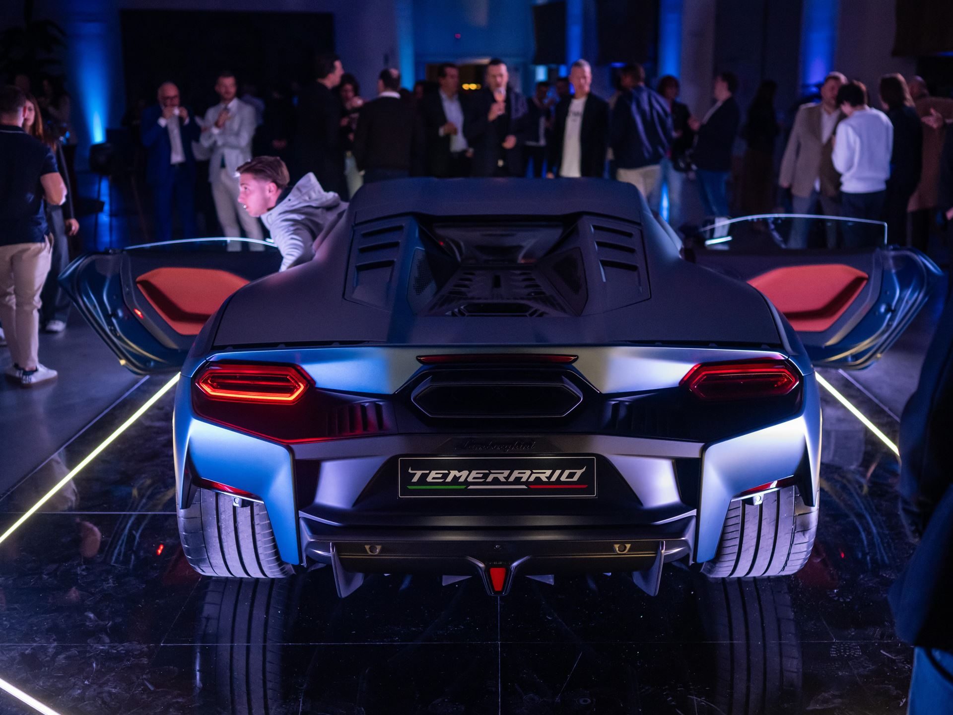 Lamborghini Temerario: A 10,000 Rpm V8 And Three Electric Motors Replace The Huracán 11 Rear view of blue lamborghini temerario showing hexagonal taillights, aggressive rear diffuser, and central exhaust outlet