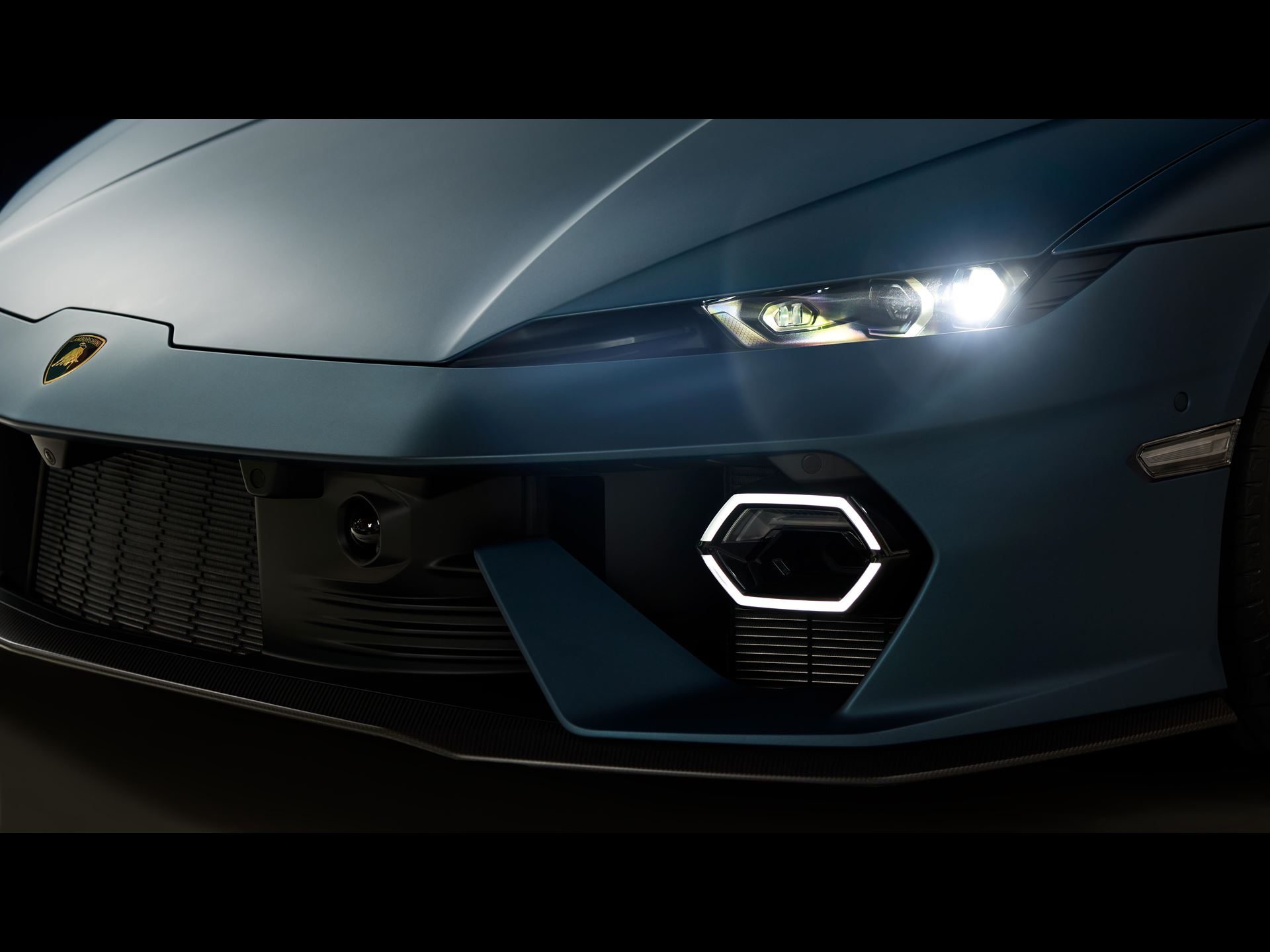 Detailed front quarter view of the Lamborghini Temerario showing illuminated Y-shaped headlights and hexagonal DRLs in matte blue