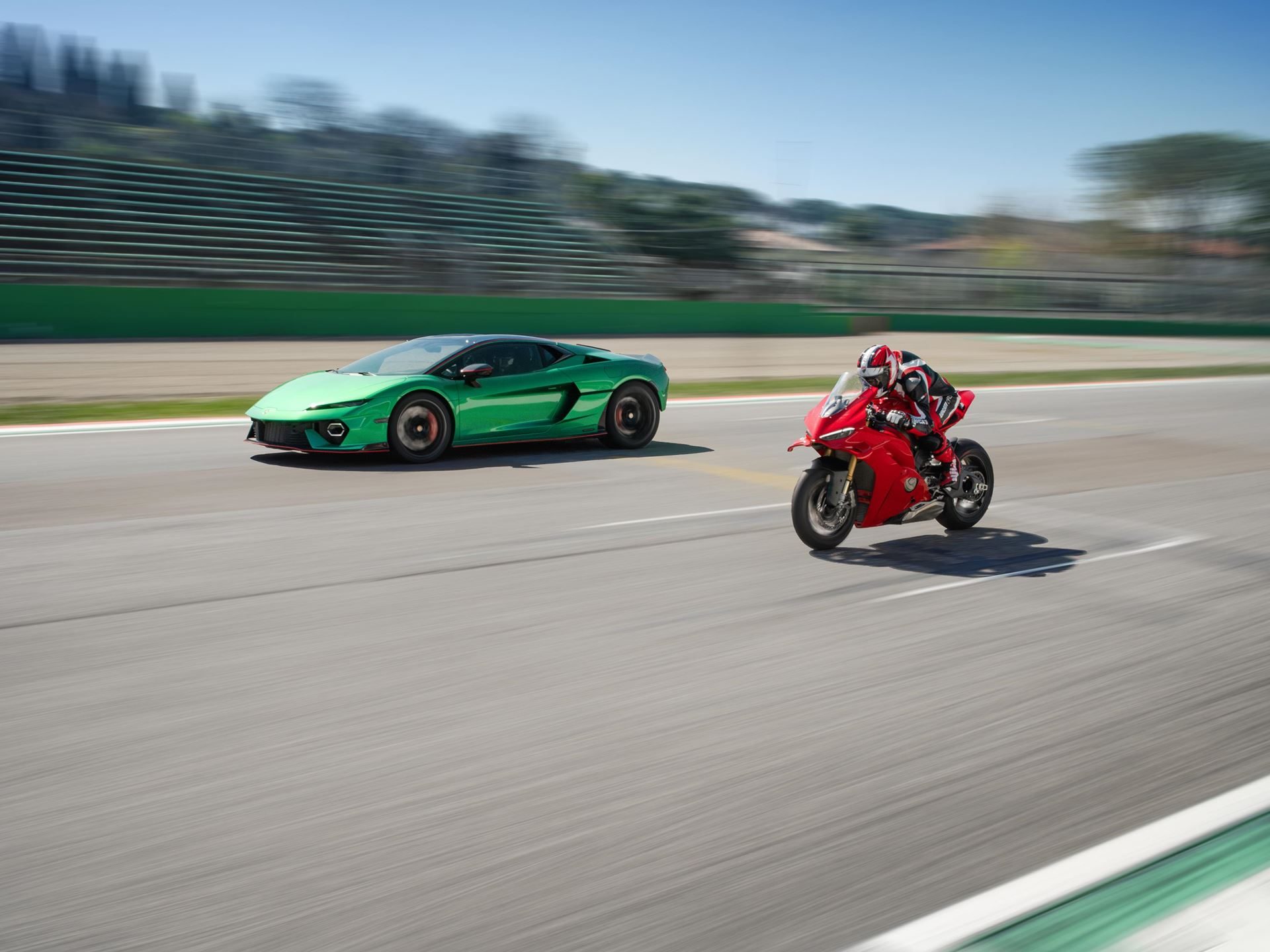 Lamborghini Temerario Takes On Ducati'S Panigale V4 At Imola, And The 10,000 Rpm V8 Does The Talking 3 Green lamborghini temerario and red ducati panigale v4 in high-speed motion on the imola circuit with significant motion blur