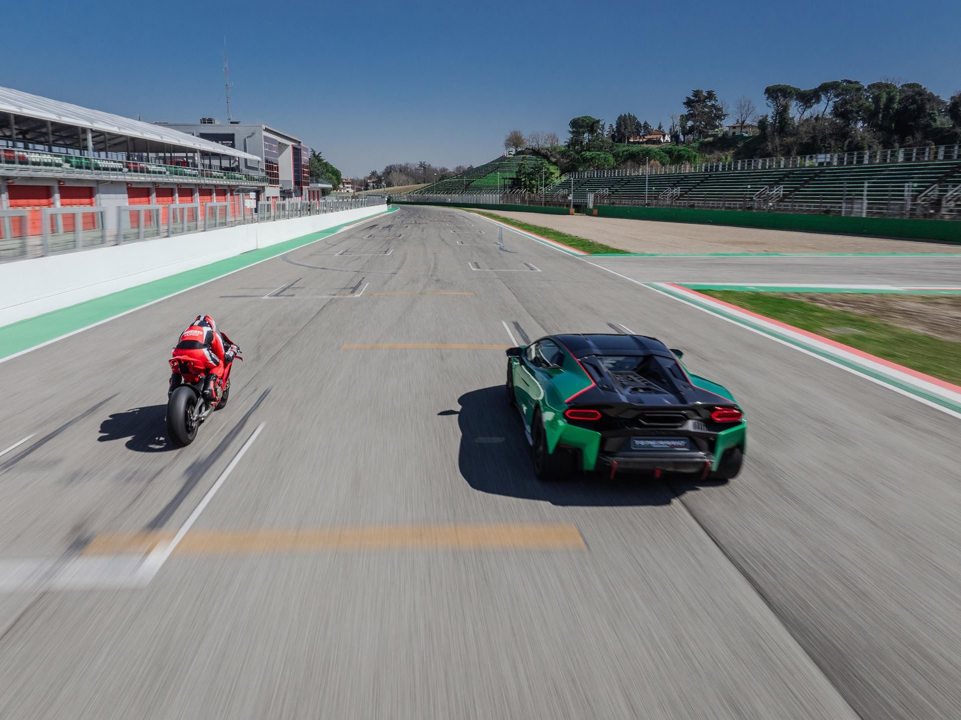 Lamborghini Temerario Takes On Ducati'S Panigale V4 At Imola, And The 10,000 Rpm V8 Does The Talking 5 Rear view of the green lamborghini temerario and red ducati panigale v4 racing away from the camera at imola, showing the temerario's aggressive rear diffuser and distinctive taillights