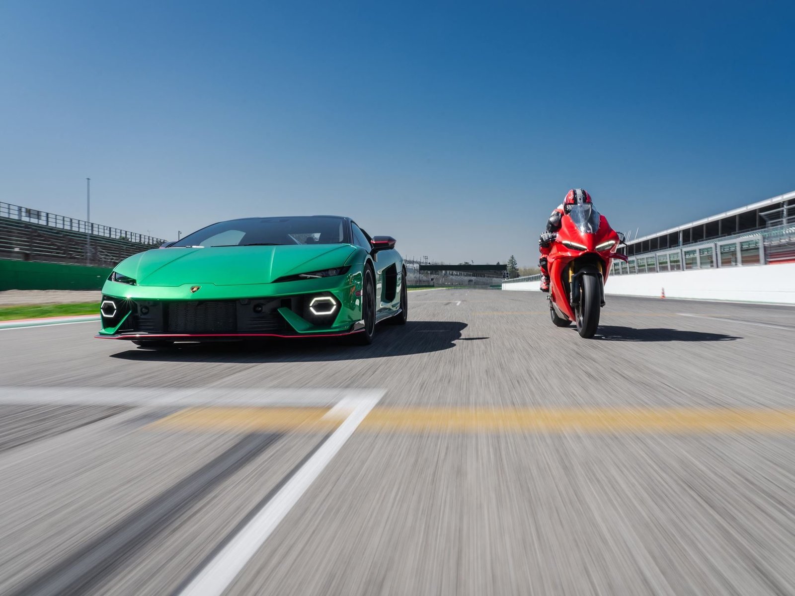 Green Lamborghini Temerario racing side-by-side with a red Ducati Panigale V4 on the Imola circuit straight