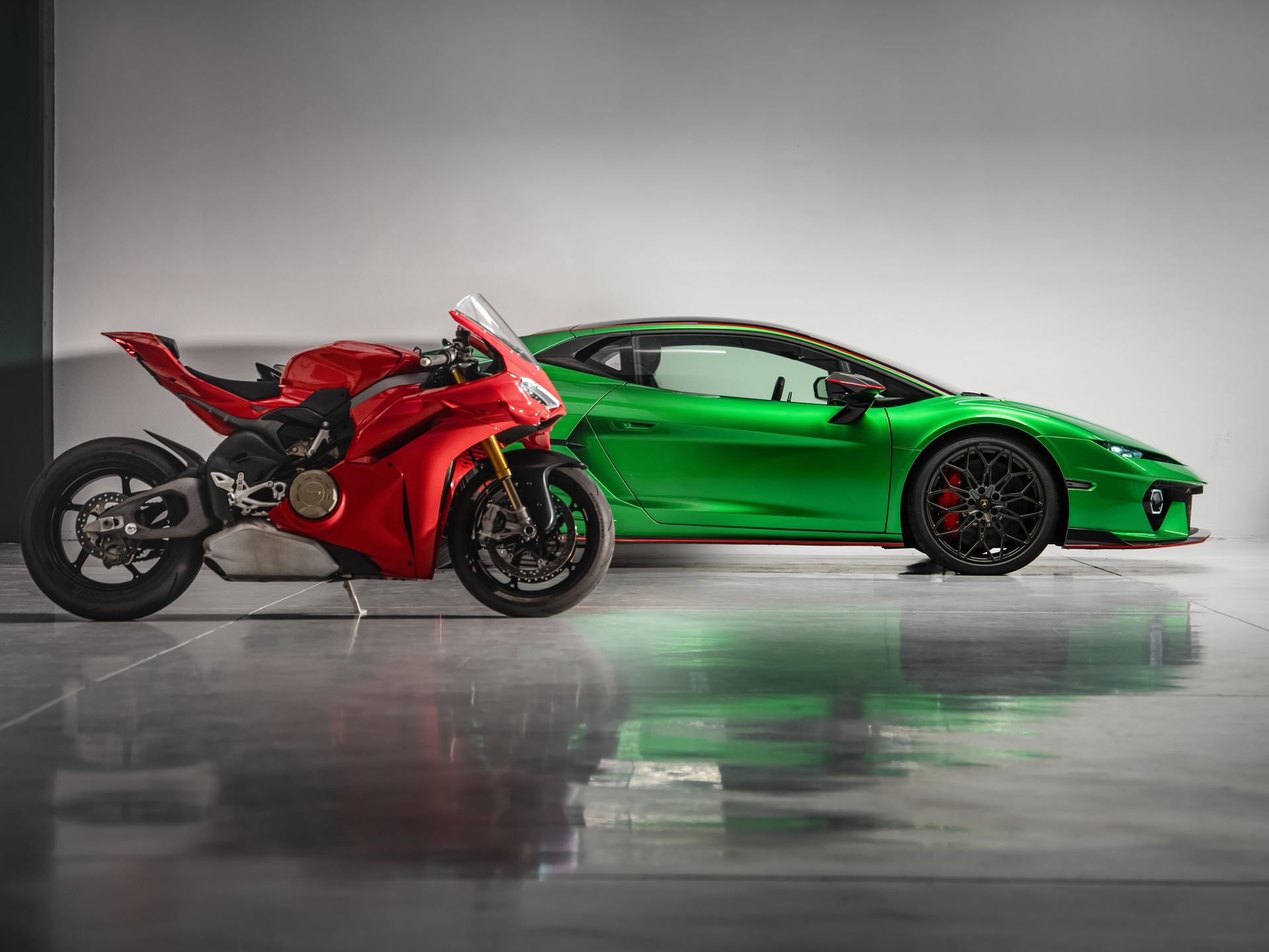 Lamborghini Temerario Takes On Ducati'S Panigale V4 At Imola, And The 10,000 Rpm V8 Does The Talking 7 Green lamborghini temerario and red ducati panigale v4 parked side-by-side in a studio setting, highlighting the dramatic size difference between the supercar and superbike