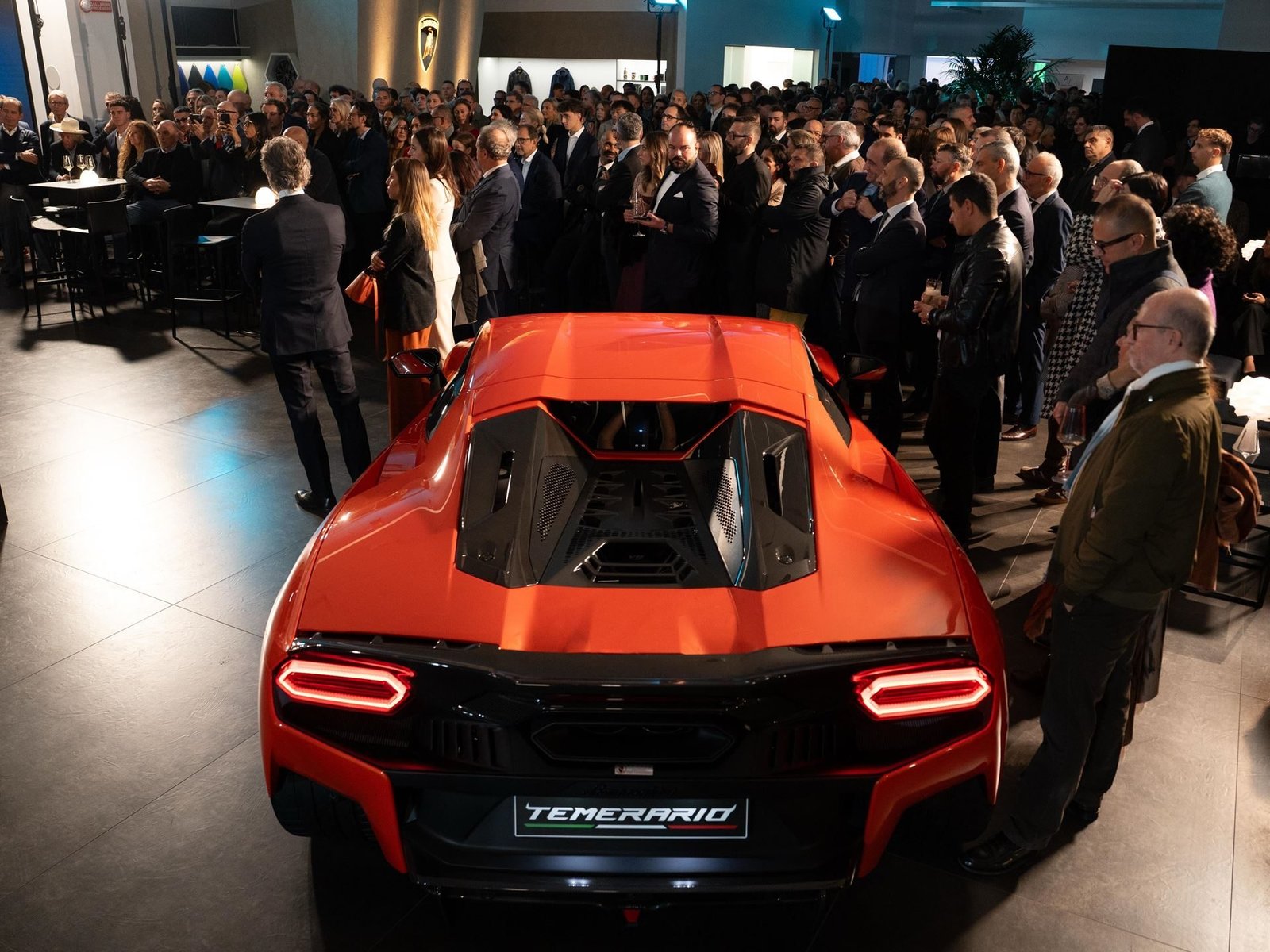 Red Lamborghini Temerario on display at the Turin showroom grand opening, surrounded by attendees