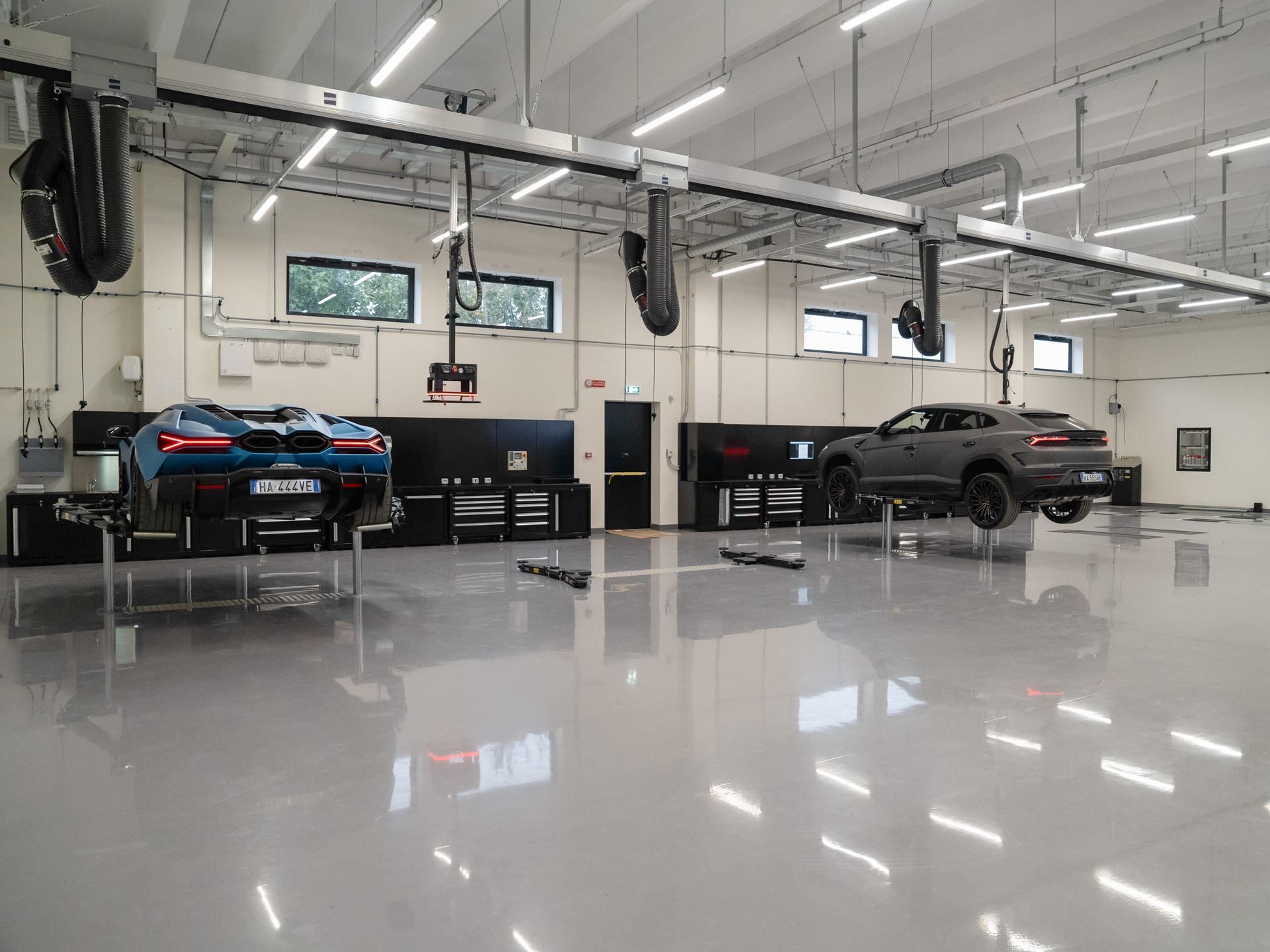 Lamborghini'S Seventh Italian Showroom Opens In Turin With 1,400 Square Meters And A 10,000-Rpm Centerpiece 9 Modern lamborghini service bay in turin with a blue revuelto and grey urus elevated on lifts