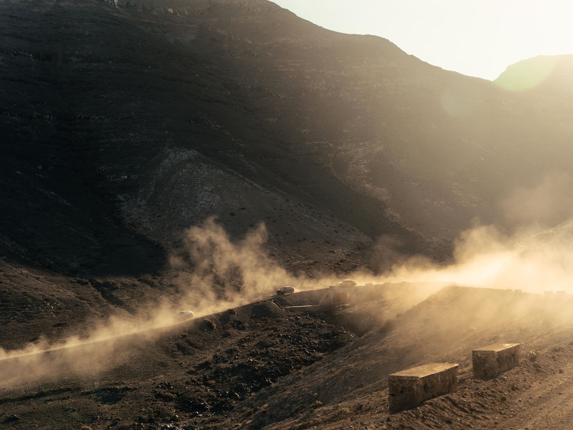 Lanzarote'S Volcanic Terrain Becomes The Proving Ground For Lamborghini'S Plug-In Hybrid Urus Se 3 Lamborghini urus suvs kicking up dust on a winding dirt road through rugged mountainous terrain in lanzarote