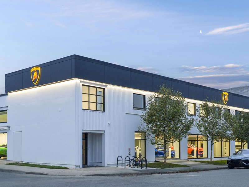 Exterior view of the redesigned Lamborghini Vancouver showroom at dusk with illuminated Lamborghini logos