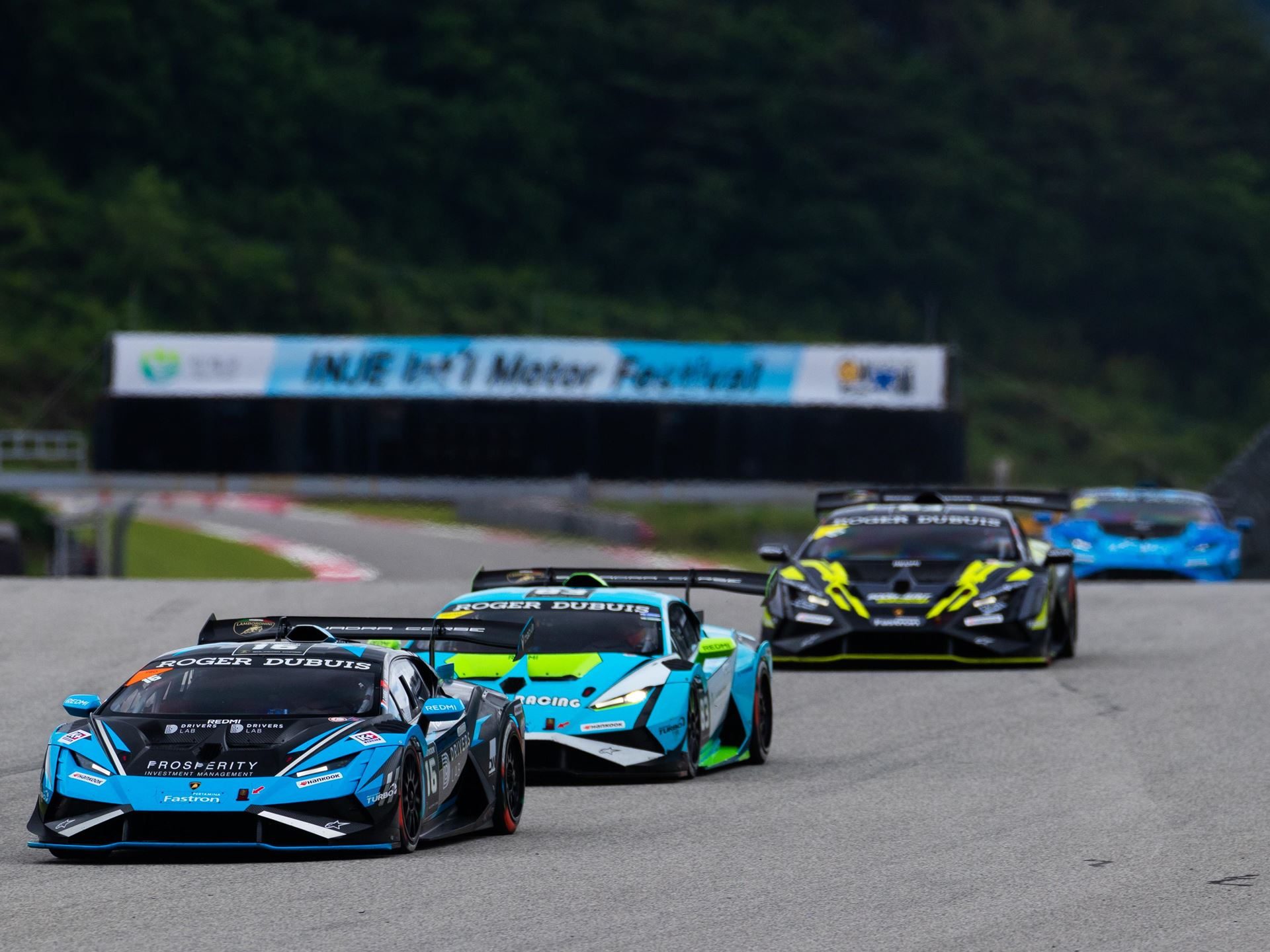 Eight Titles Still On The Line As 132 Drivers Converge On Misano For The 12Th Lamborghini World Finals 5 A line of lamborghini huracán super trofeo evo2 cars racing on track with a blue and black car in the lead