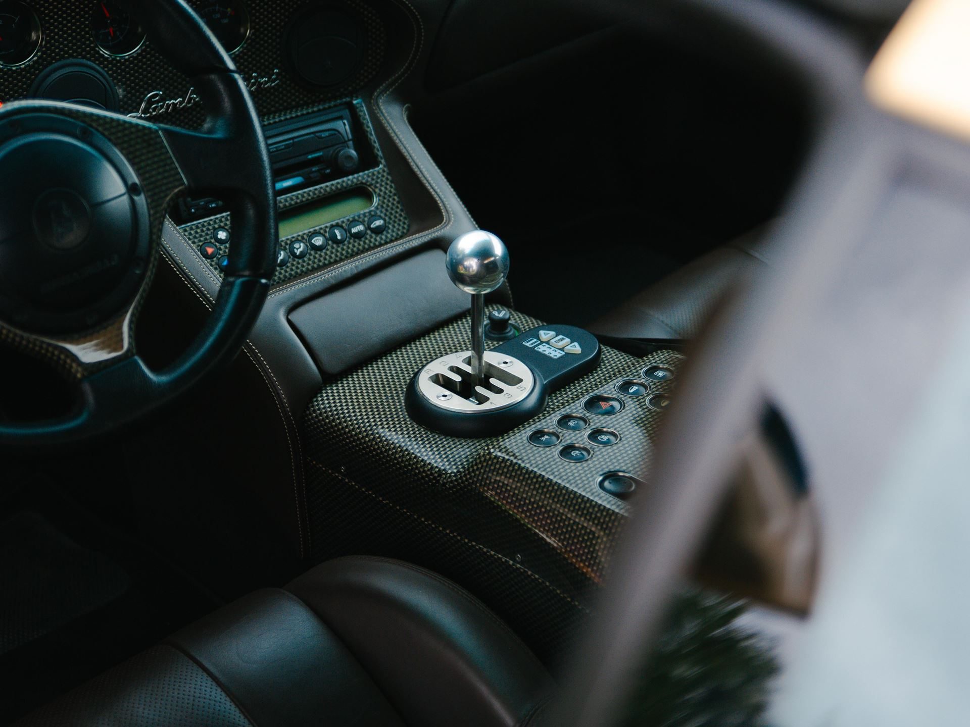 Close-up of lamborghini diablo vt 6. 0 gated manual shifter and carbon fiber center console trim