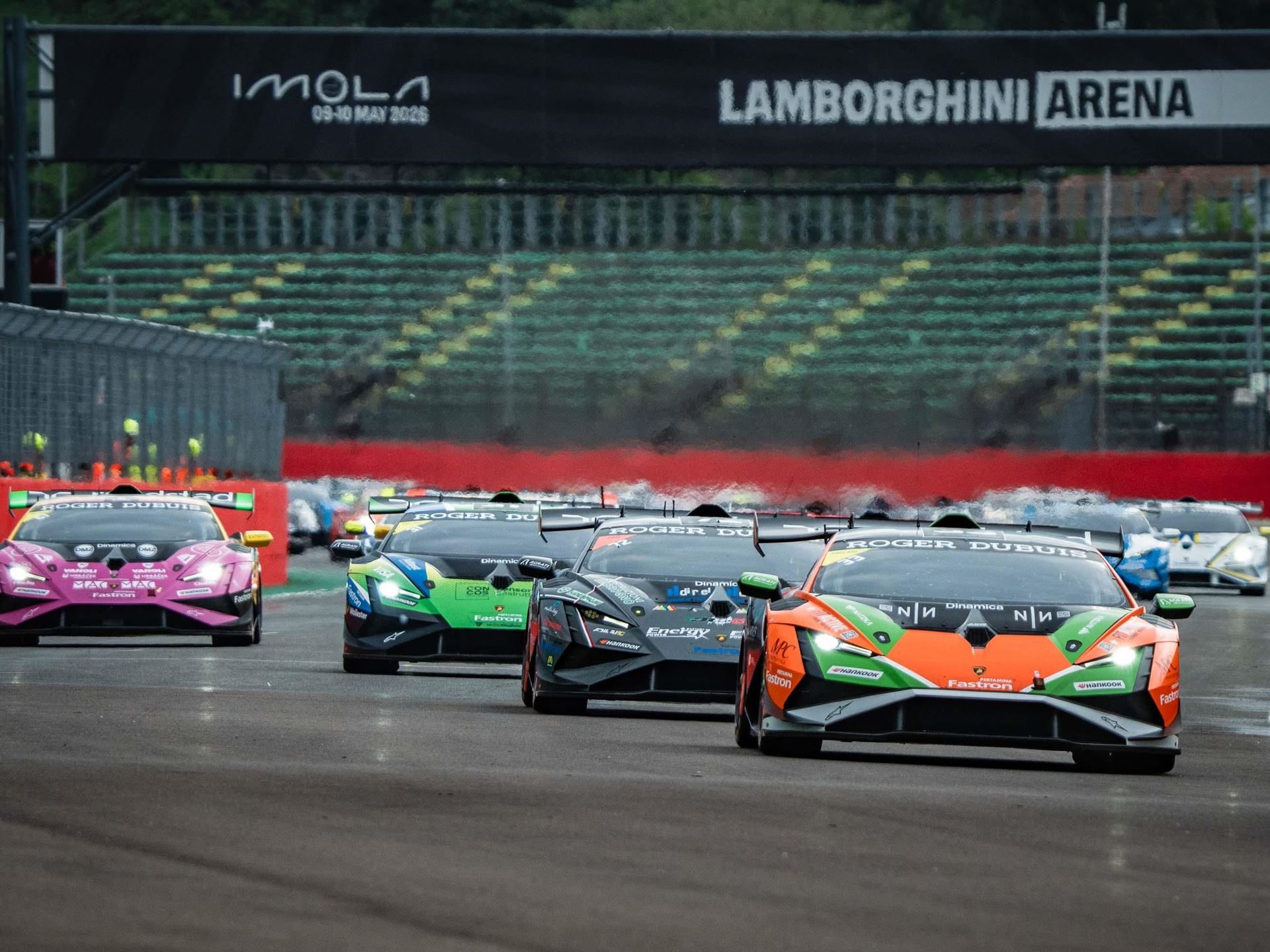 A full grid of lamborghini huracán super trofeo evo2 cars in diverse liveries lines up under the lamborghini arena banner
