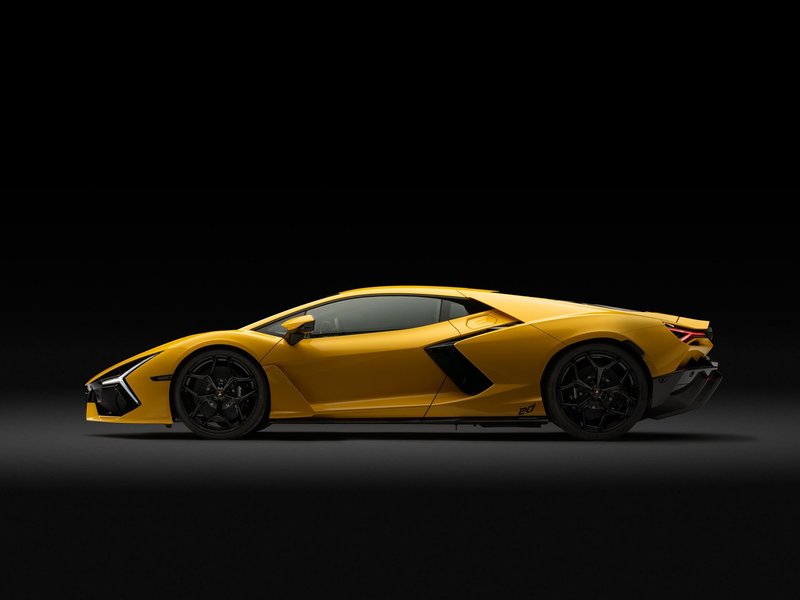 Yellow Lamborghini Revuelto Ad Personam 20th Anniversary in studio lighting, showing its sleek side profile and aggressive design