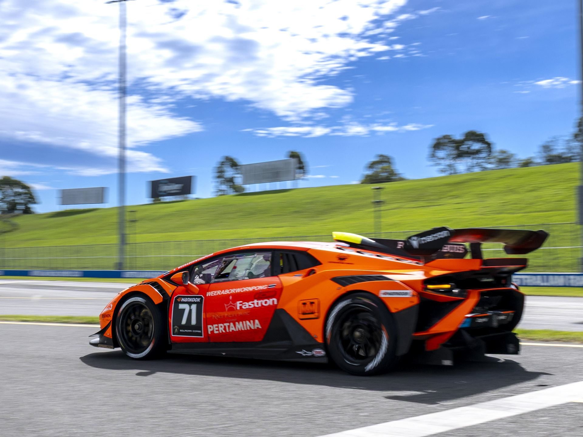 22 V10 Huracáns Descend On Shanghai As Super Trofeo Asia'S Class Battles Tighten 7 An orange lamborghini huracán super trofeo evo2 accelerates on track under blue sky, large rear wing and side exhaust visible