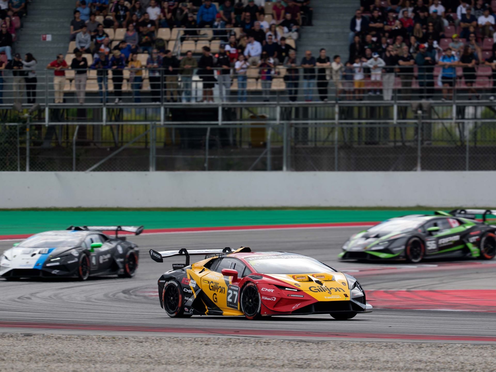 Cmr'S Dimitrov And Guerin Lock Up Super Trofeo Europe Pro-Am Title With A Round To Spare 7 A red and yellow lamborghini huracán super trofeo evo2 leads two other cars through a corner with spectators visible in the grandstands