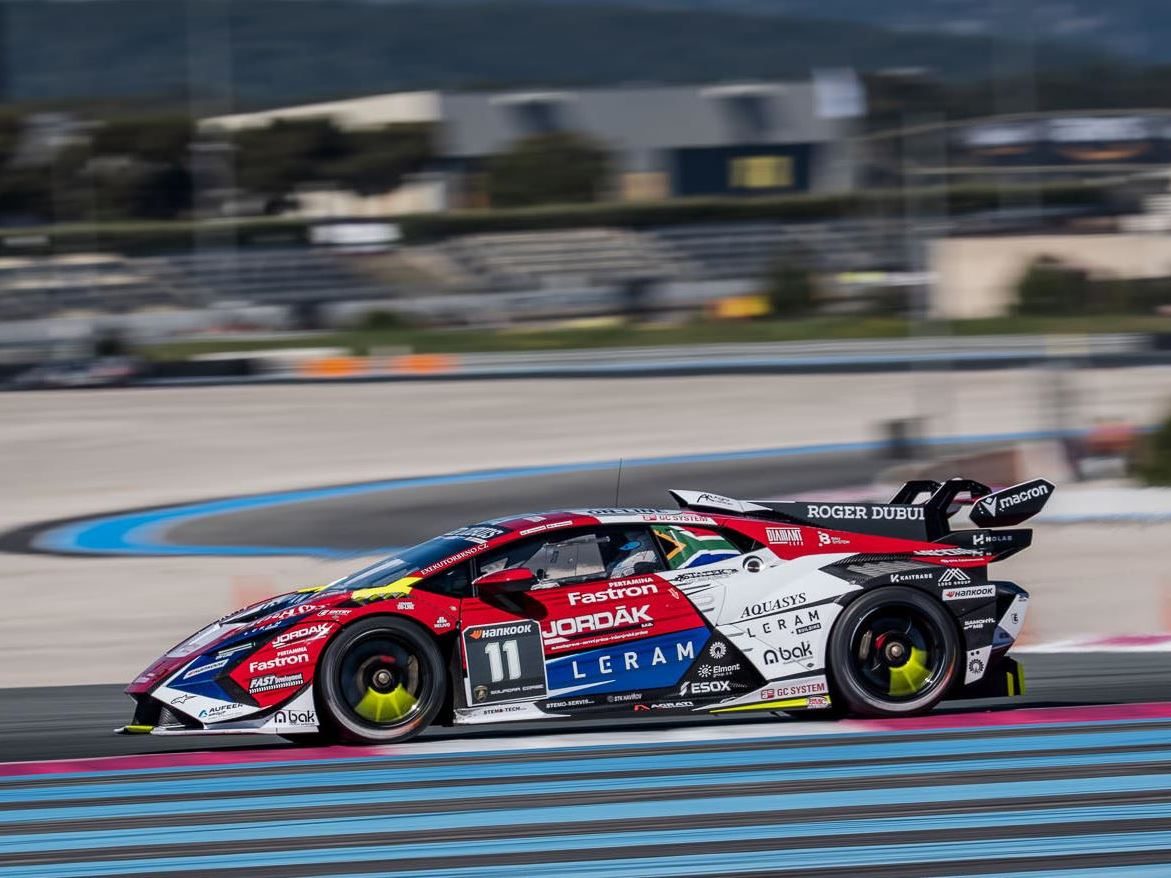 A red, white, and blue liveried lamborghini huracán super trofeo evo2 number 11 racing through a corner with visible motion blur