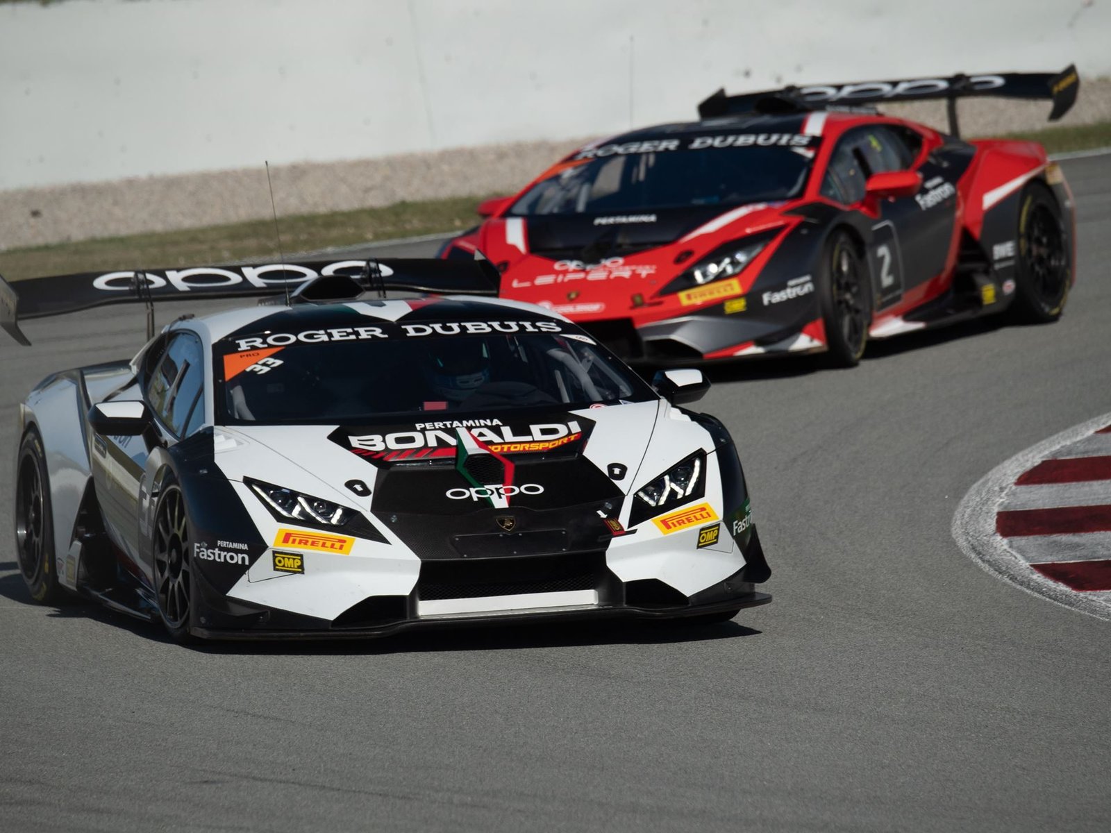 Two Huracán Super Trofeo EVO race cars in close combat through a circuit corner during the 2020 season