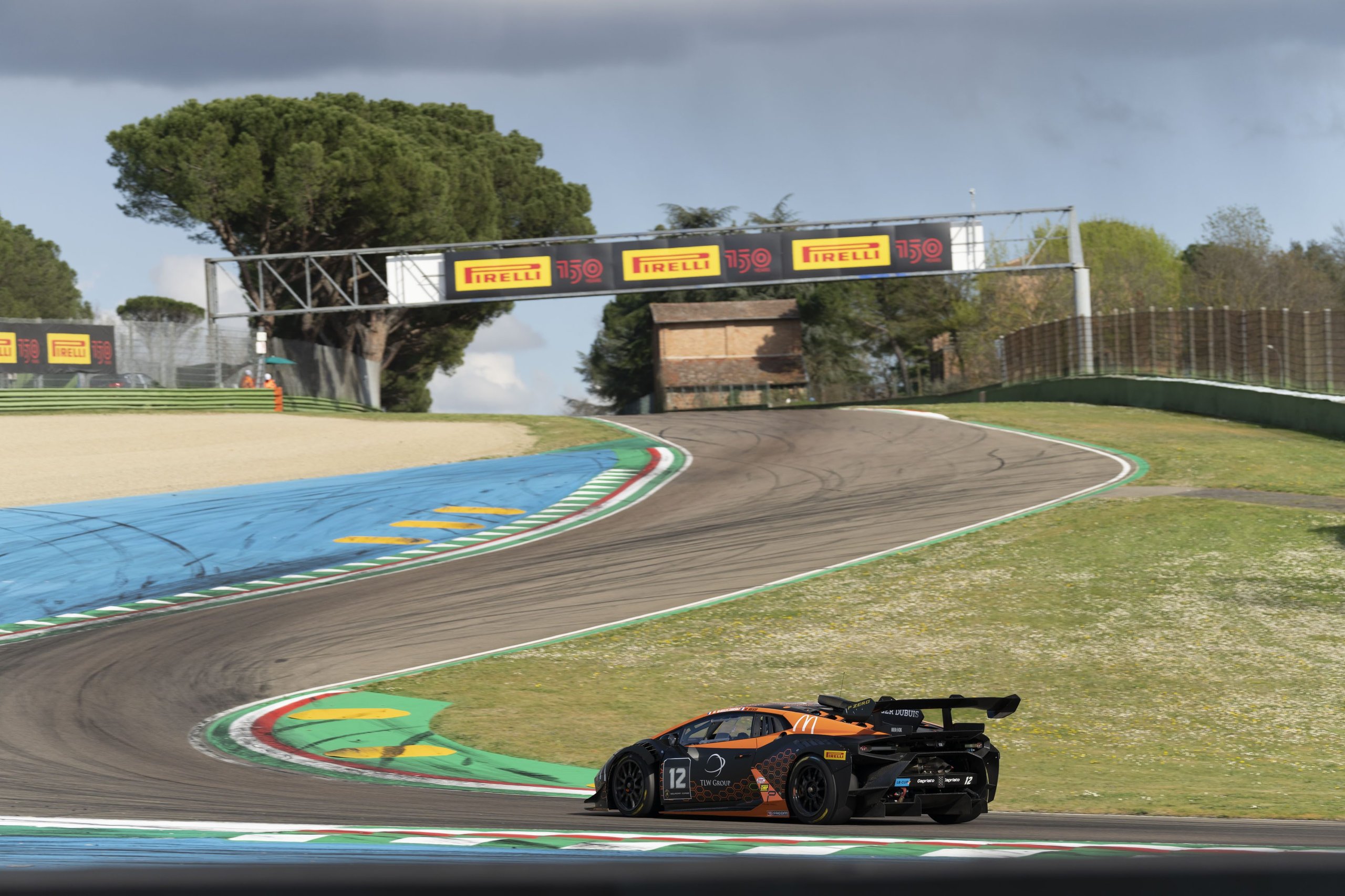 Lamborghini huracán super trofeo evo2 navigating a racetrack turn with visible rear wing and aerodynamic diffuser
