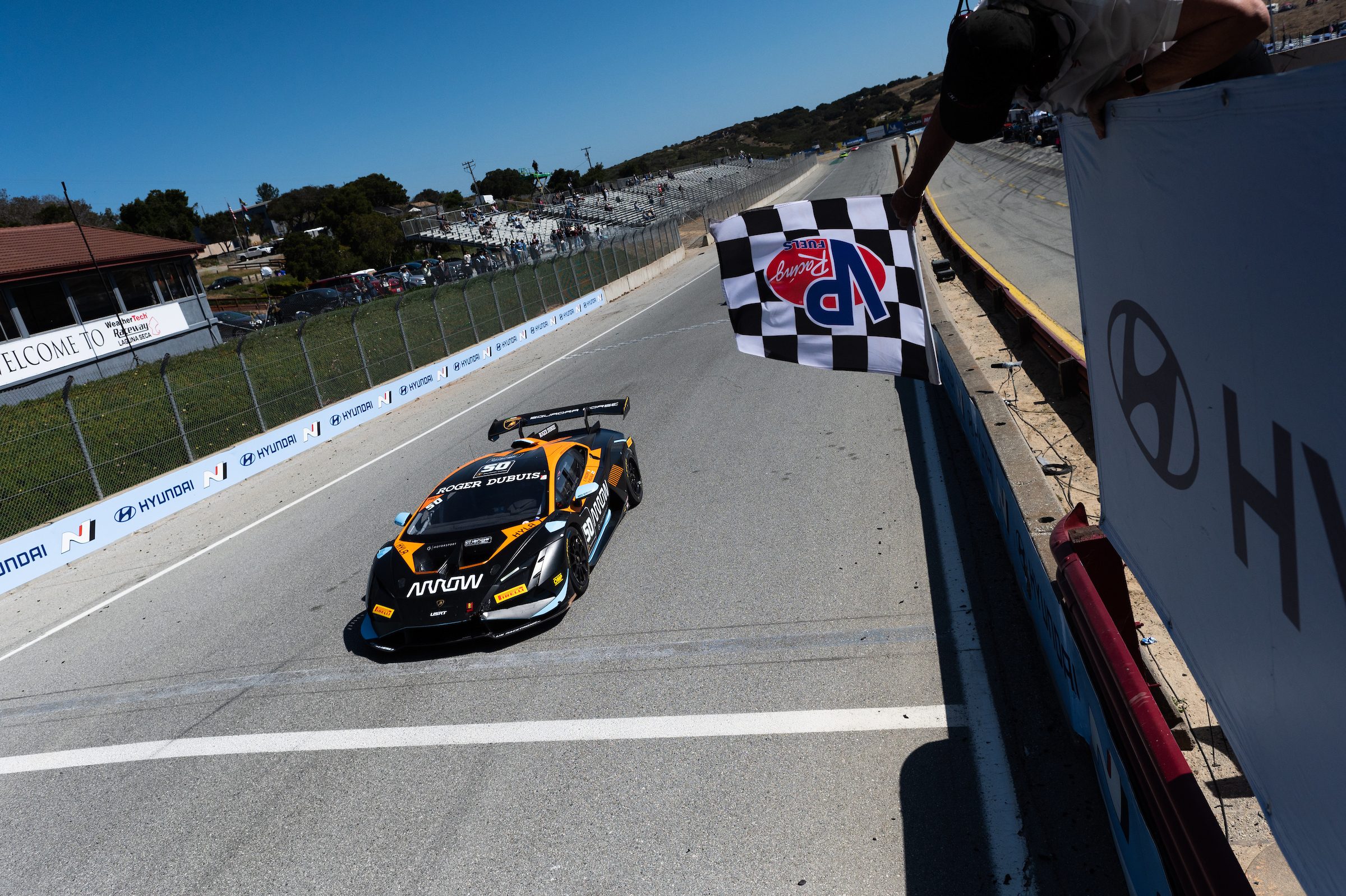 Lamborghini huracán super trofeo evo2 crossing the finish line under a checkered flag