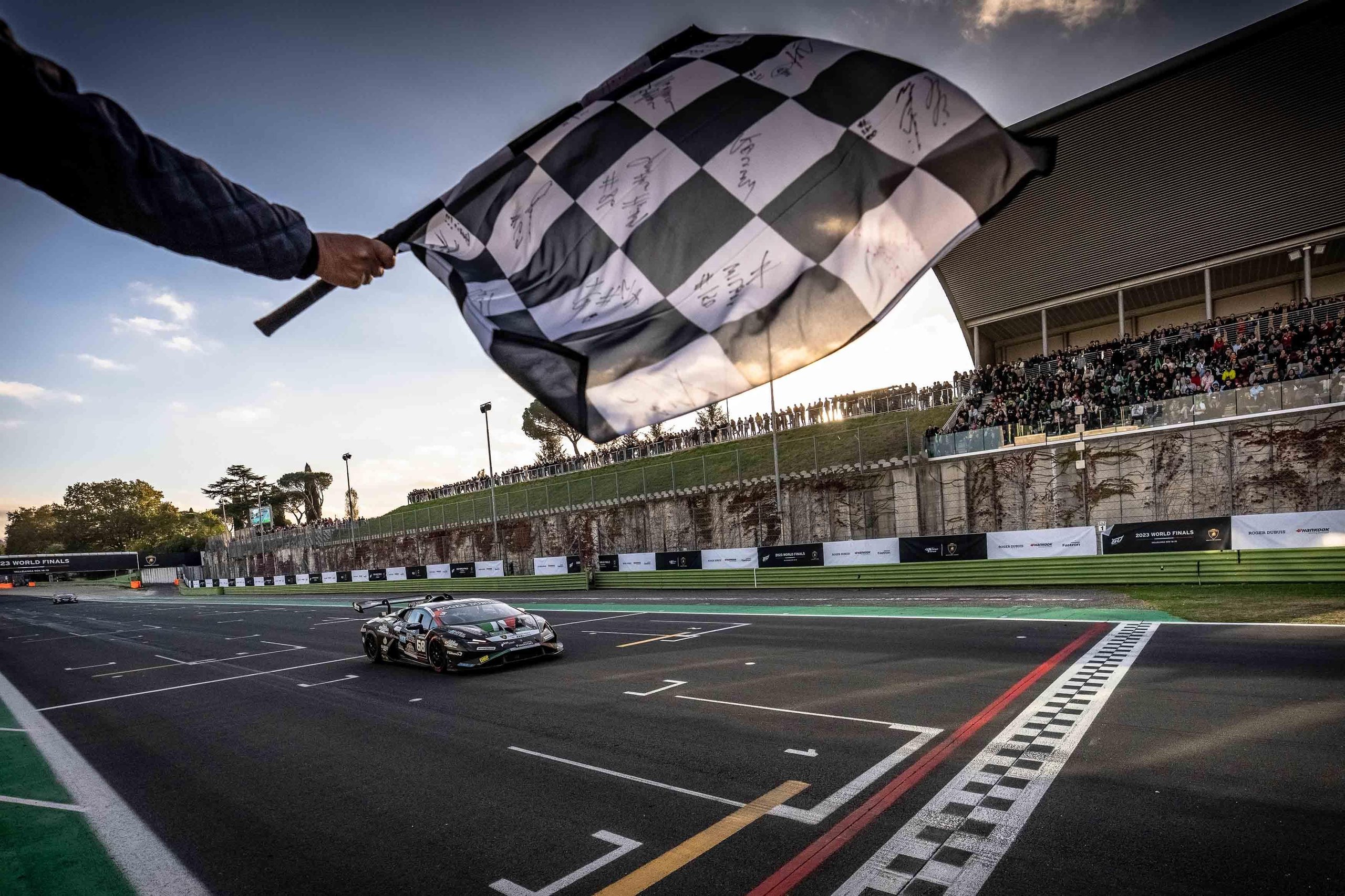 Lamborghini huracán super trofeo evo2 crosses the finish line under the checkered flag at vallelunga