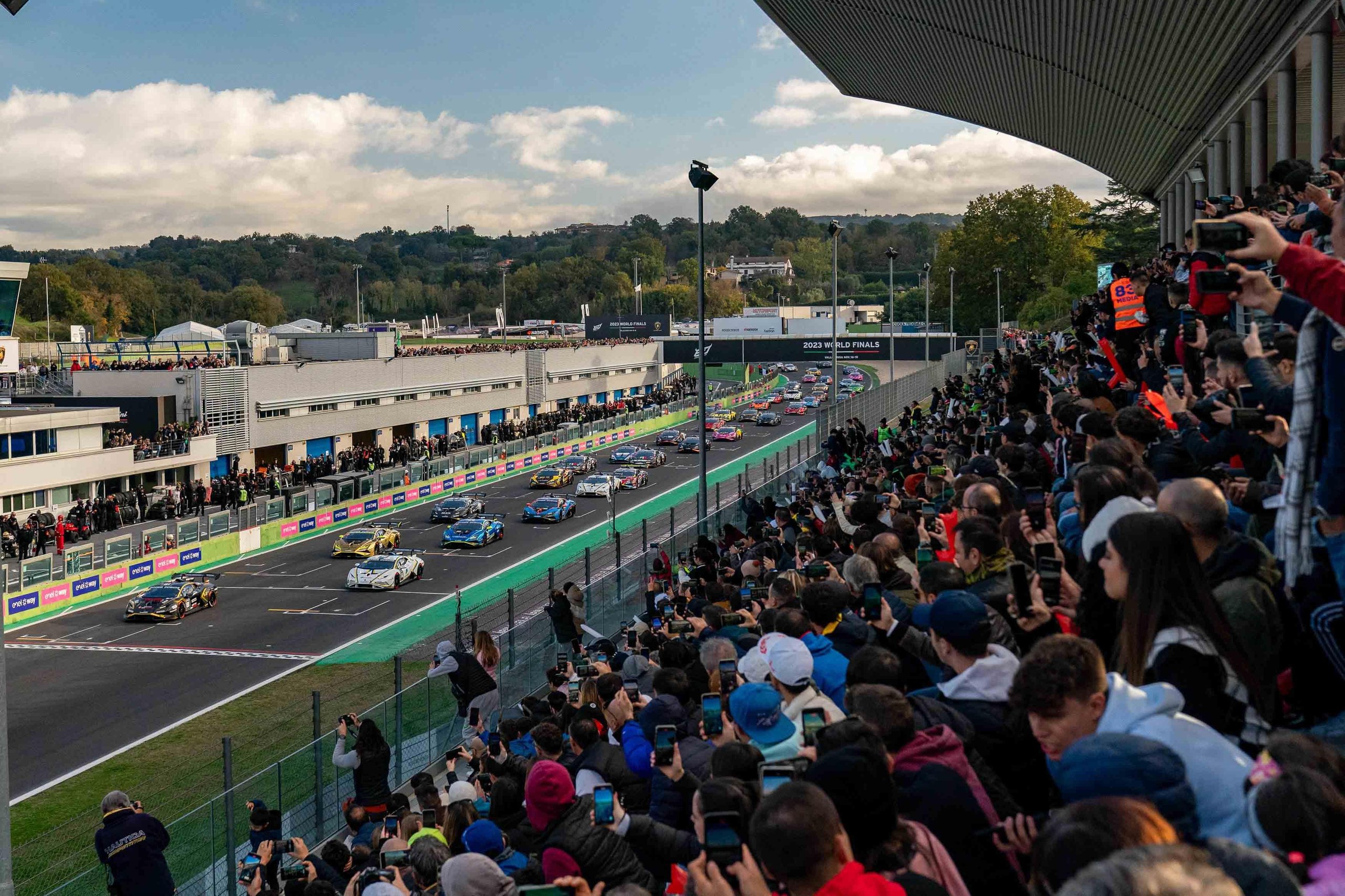 Wide shot of the packed starting grid at vallelunga with dozens of lamborghini huracán super trofeo evo2 cars and spectators lining the track