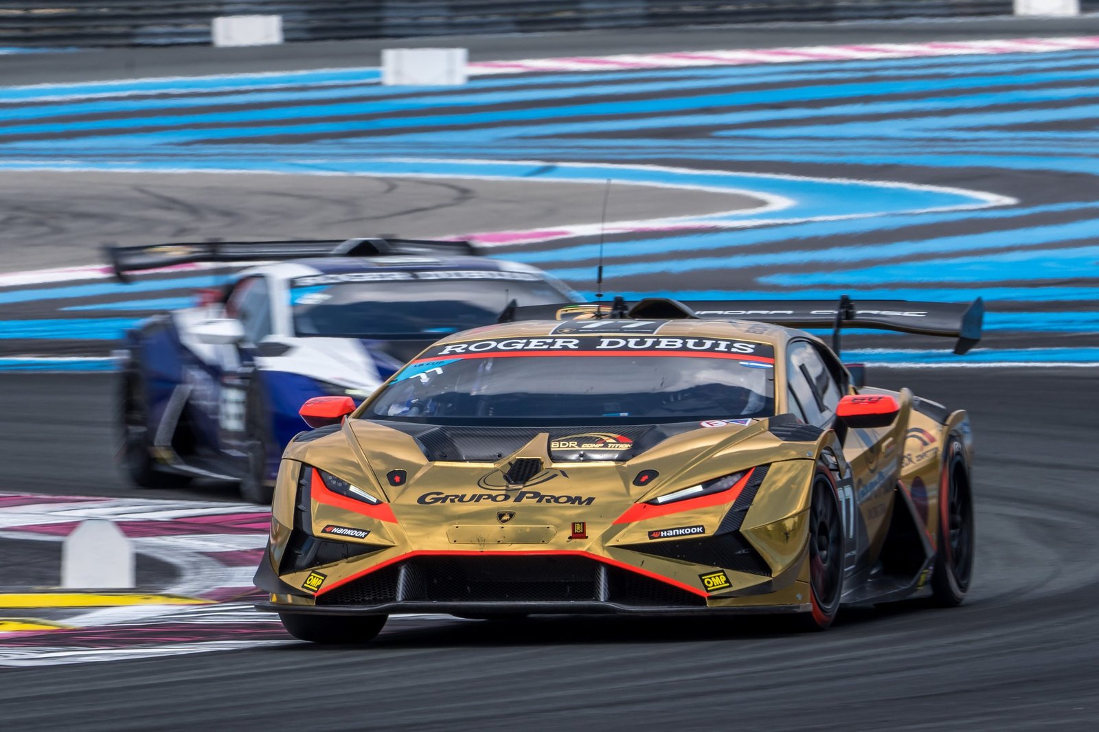 A gold Lamborghini Huracán Super Trofeo EVO2 race car leads another car on track during the 2023 Super Trofeo Europe season