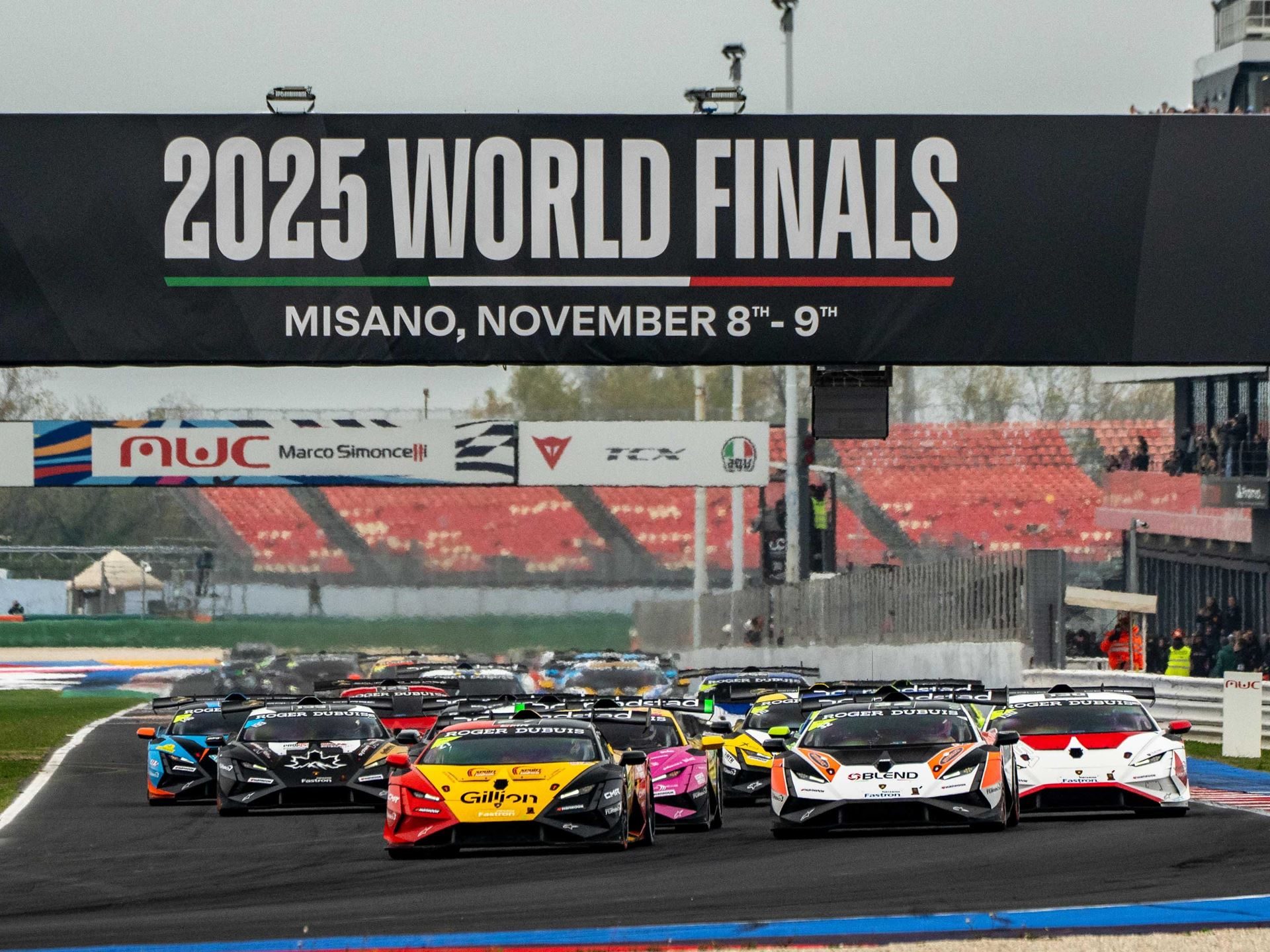 Multiple lamborghini huracán super trofeo evo2 race cars lined up at the start of a race under the 2025 world finals banner at misano