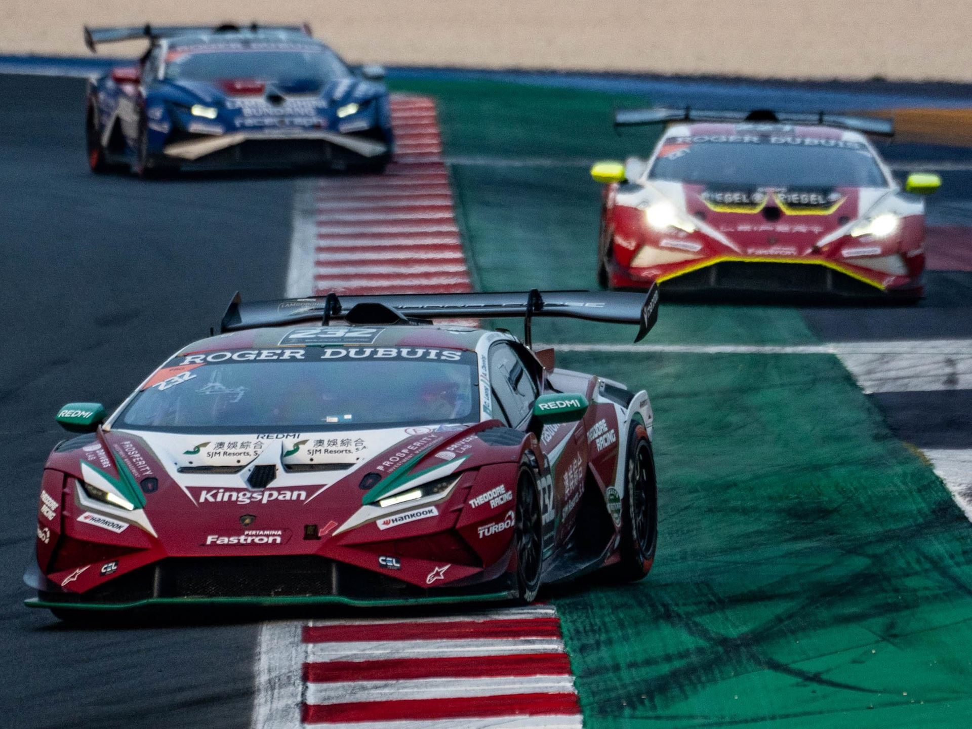One-Point Margins And Last-Lap Passes: How The 2025 Super Trofeo Season Built The Most Dramatic World Finals In Years 3 Lamborghini huracán super trofeo evo2 in red and green livery leading two other race cars through a corner at misano