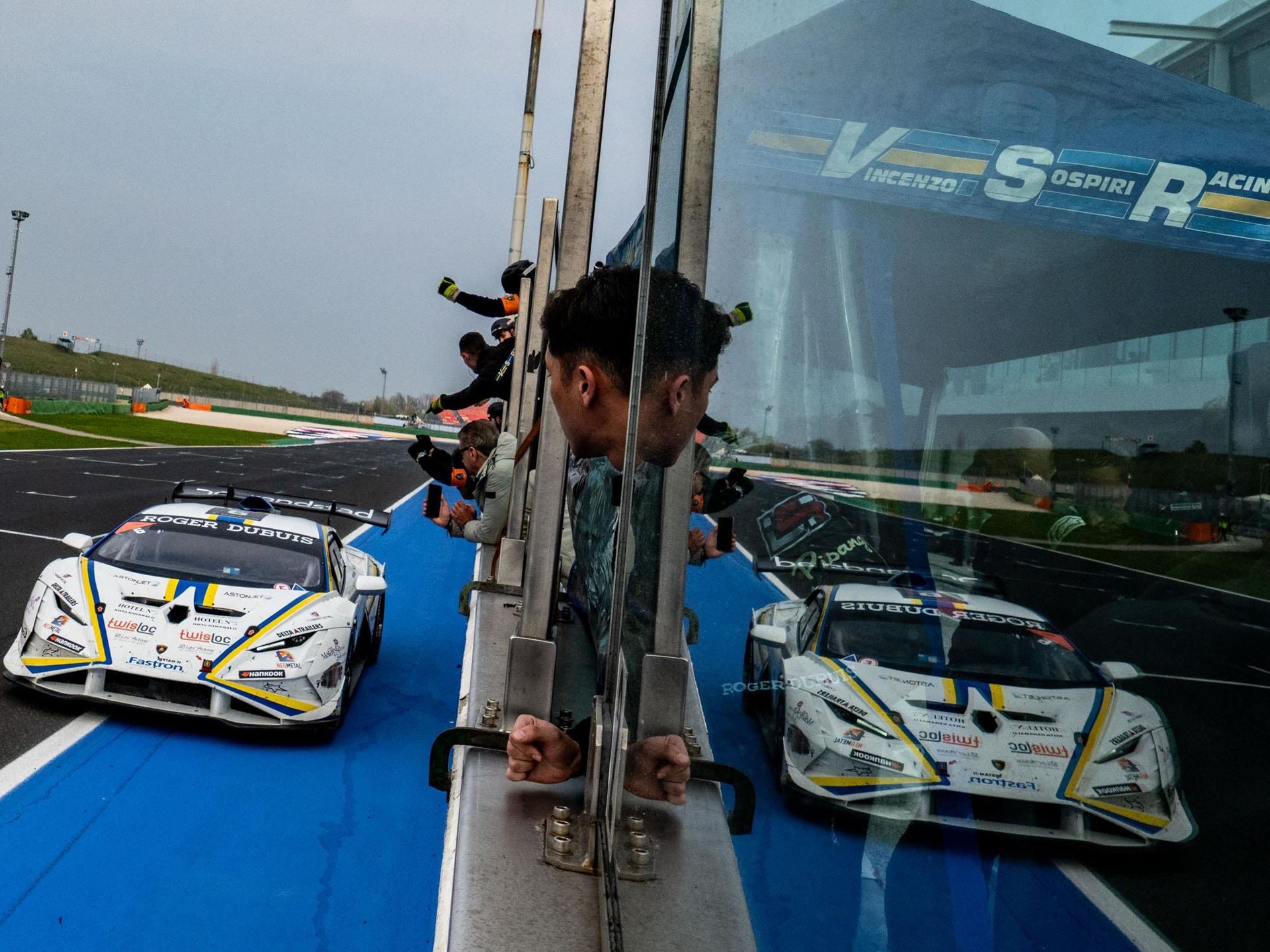 One-Point Margins And Last-Lap Passes: How The 2025 Super Trofeo Season Built The Most Dramatic World Finals In Years 5 Pit crew member watches two white lamborghini huracán super trofeo evo2 cars pass through pit lane at misano