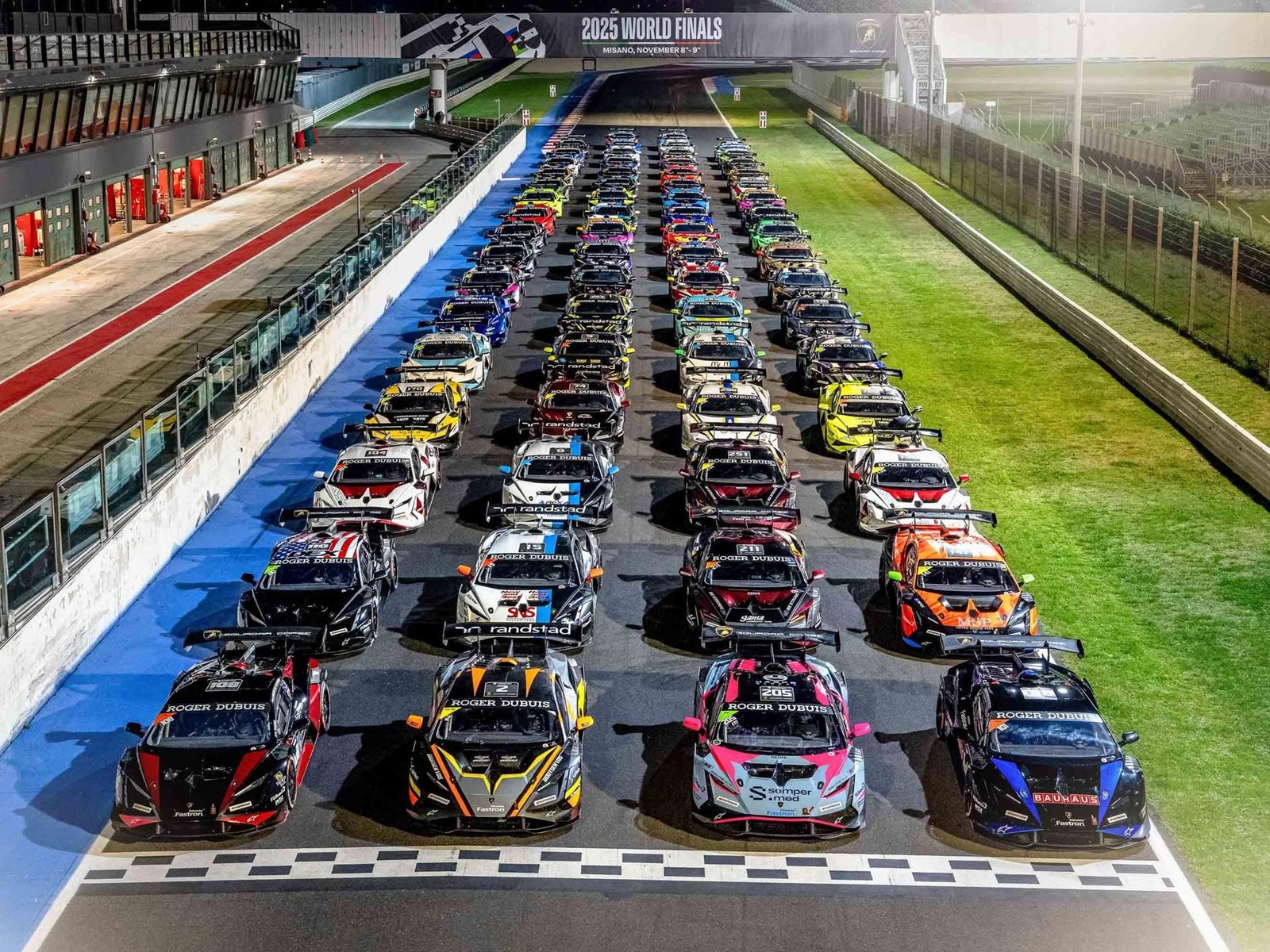 Lamborghini Huracán Super Trofeo EVO2 race cars lined up under lights at the 2025 World Finals at Misano