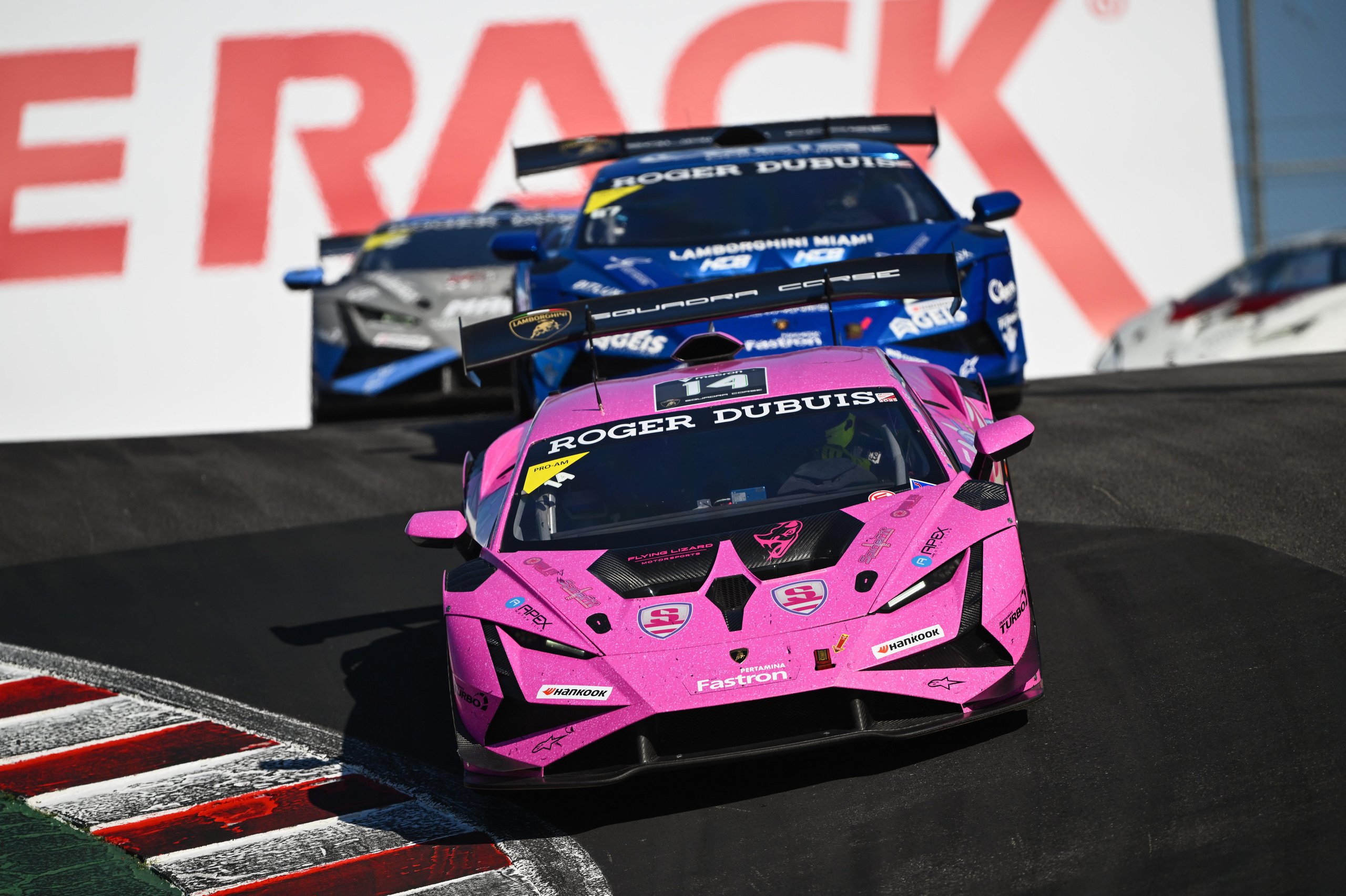 The Huracán Super Trofeo Evo2'S Final Full Season Spans 36 Races Across Three Continents Before The Temerario Takes Over 3 Close-up of a pink lamborghini huracán super trofeo evo2 race car leading two blue competitors through a turn