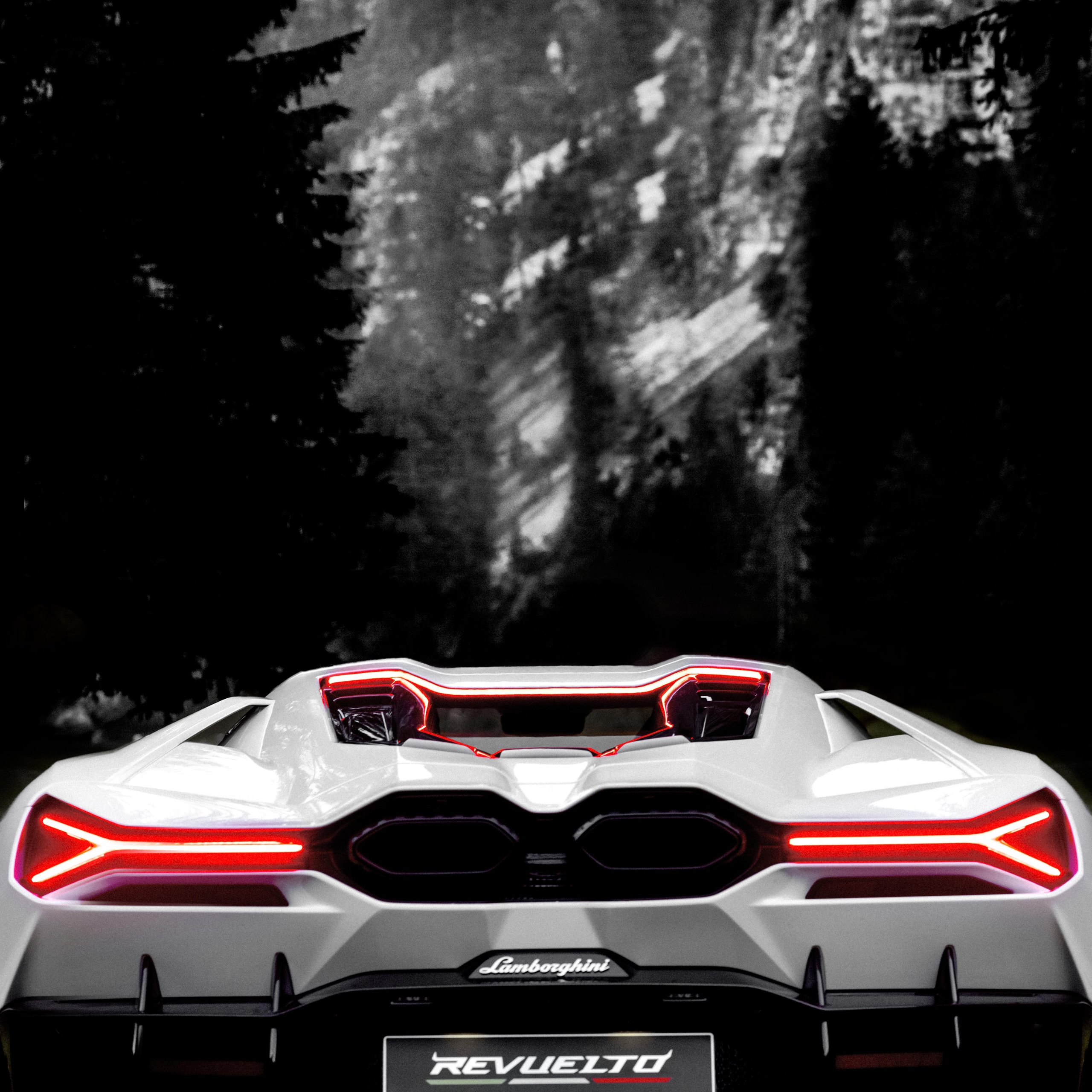 Anton Corbijn Photographs The Revuelto Like A Rock Star, And That'S Exactly Lamborghini'S Point 9 Black and white rear view of a white lamborghini revuelto with illuminated y-shaped taillights against a dark blurred forest